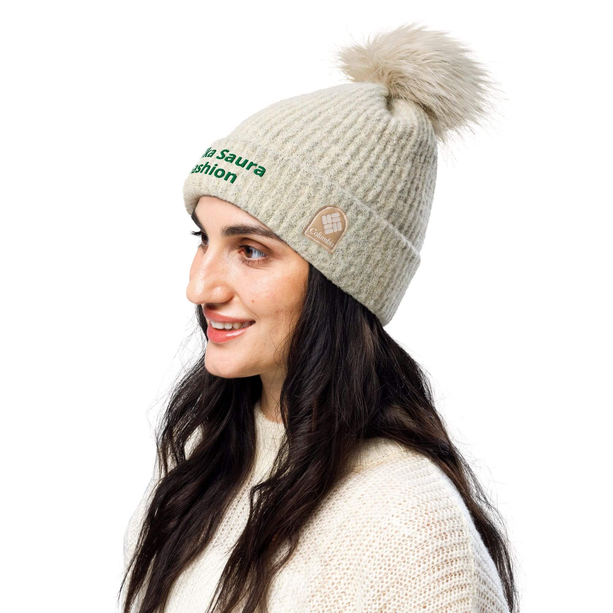 Woman wearing beige pom-pom knit hat.