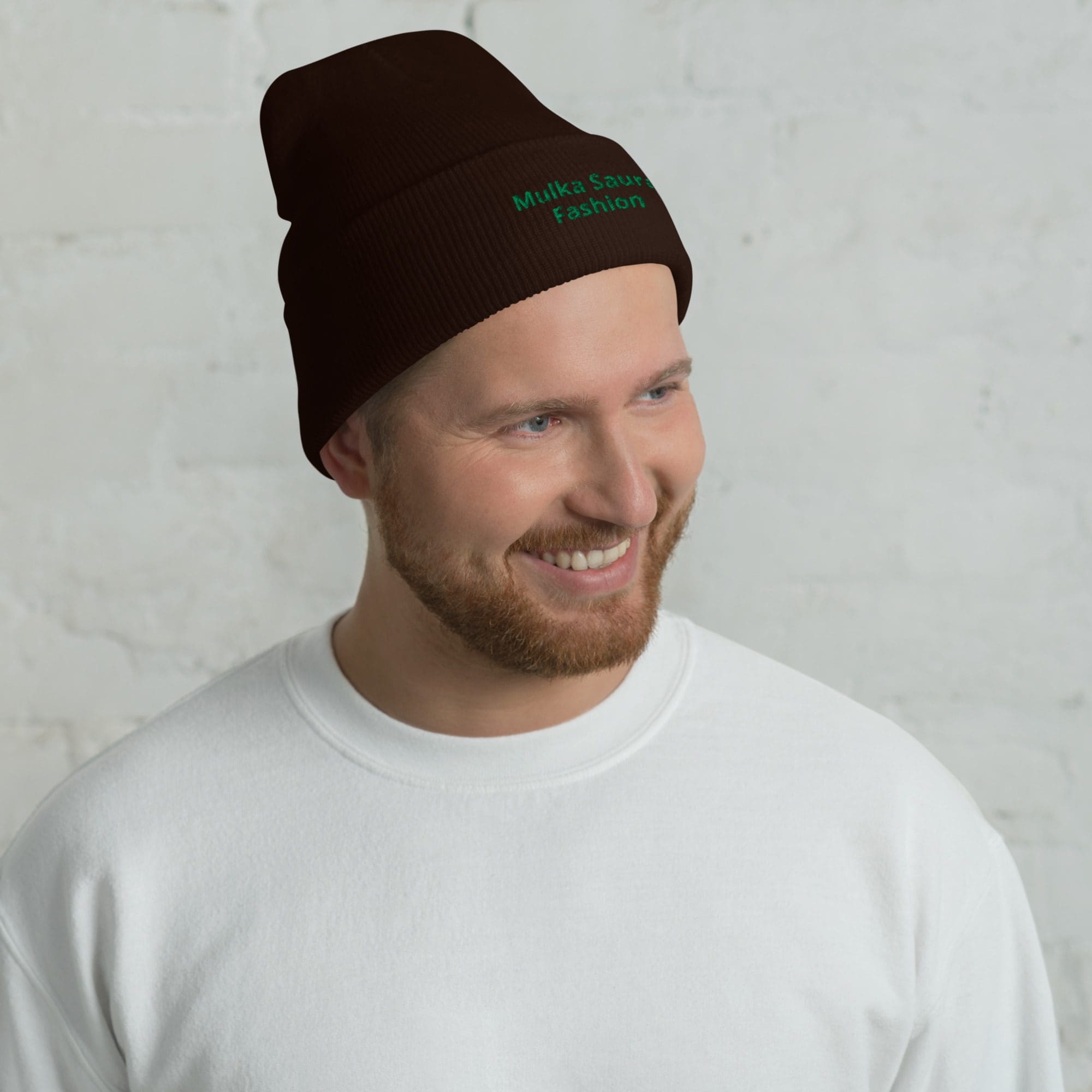 Man wearing brown beanie and white shirt.