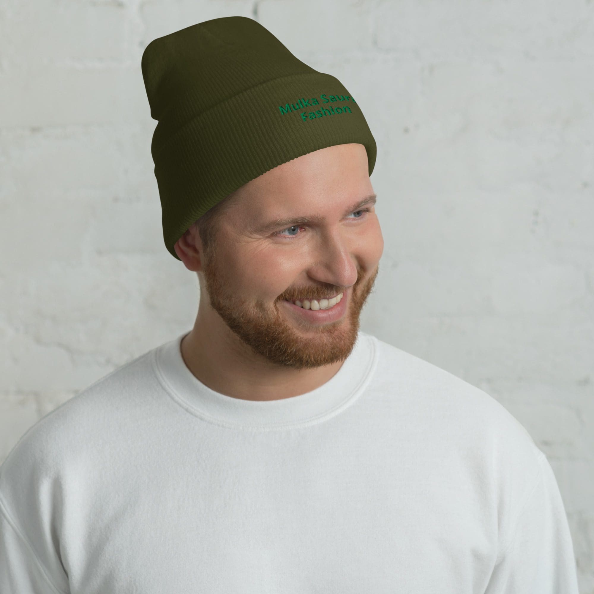 Man wearing green beanie and white sweater.