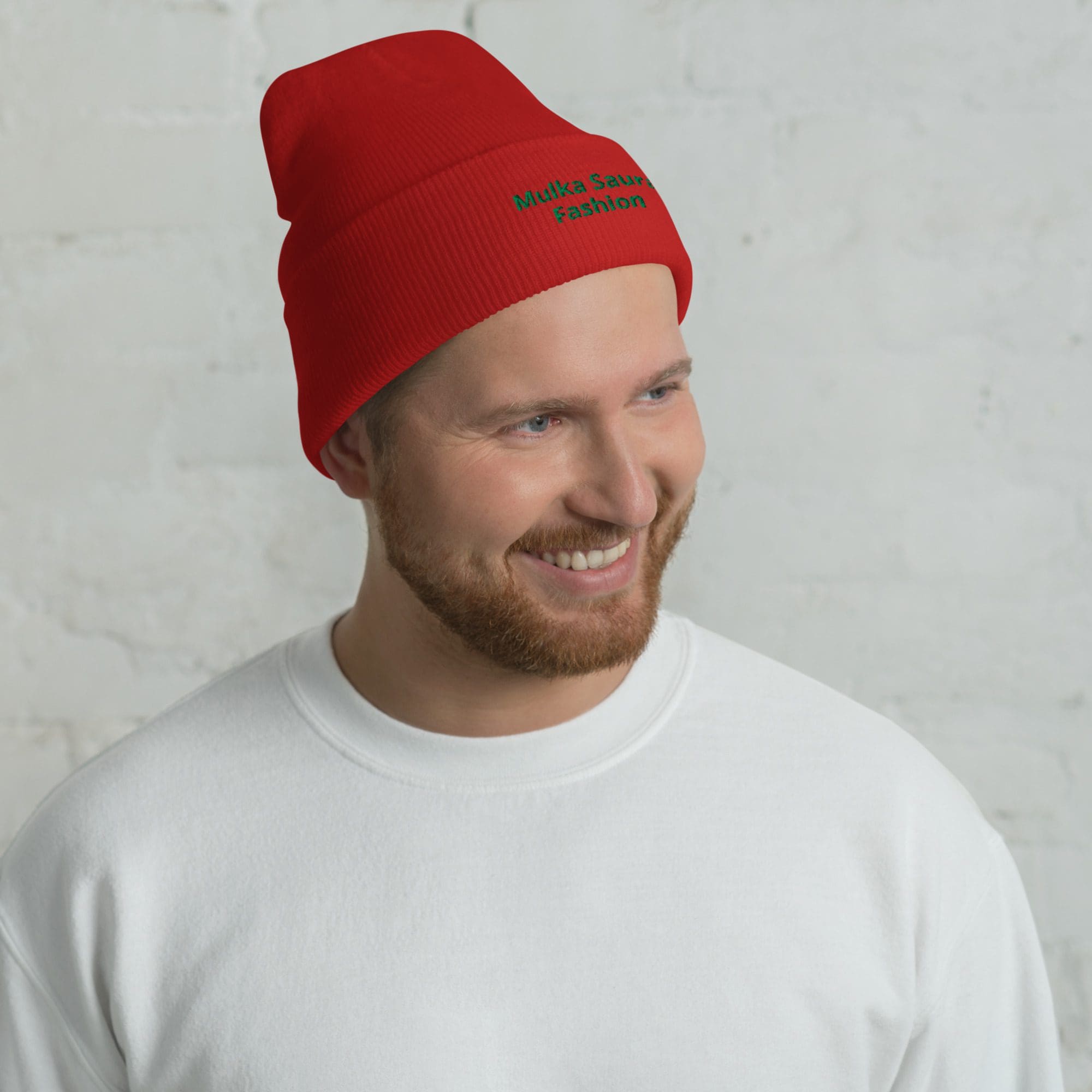 Man wearing red beanie and white sweater.