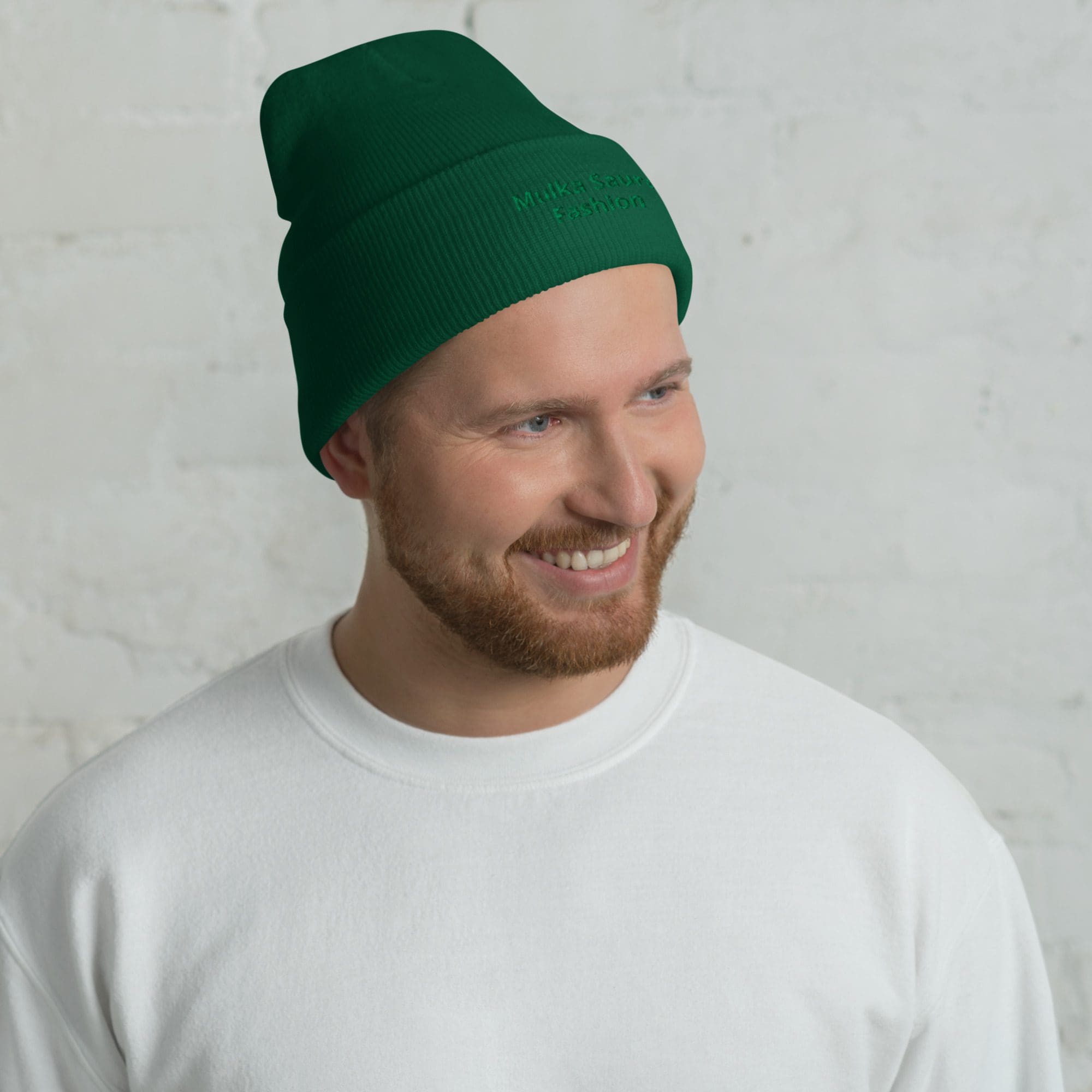Man wearing green beanie and white shirt.