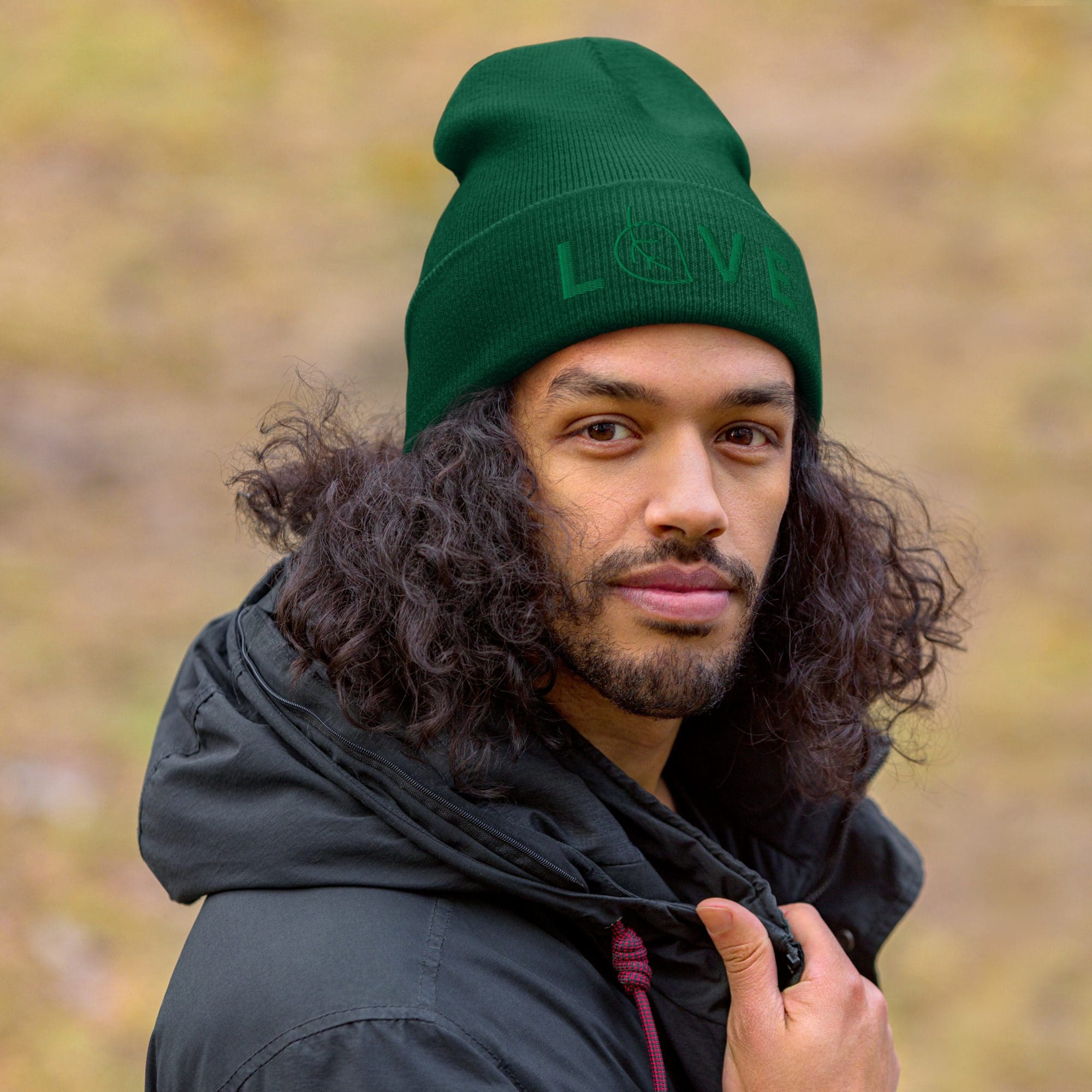 Man wearing green beanie and black jacket.