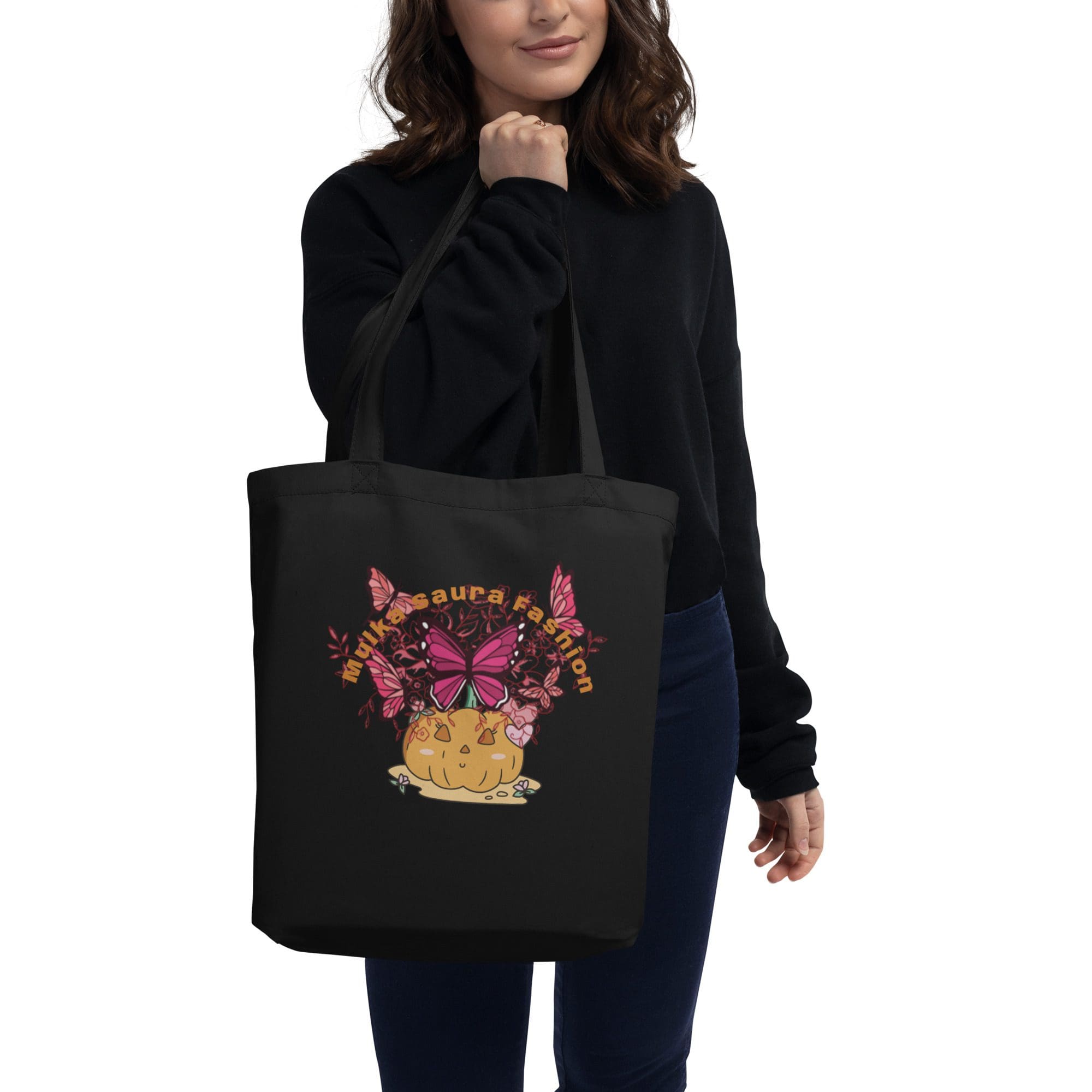Woman holding black tote with butterfly design.