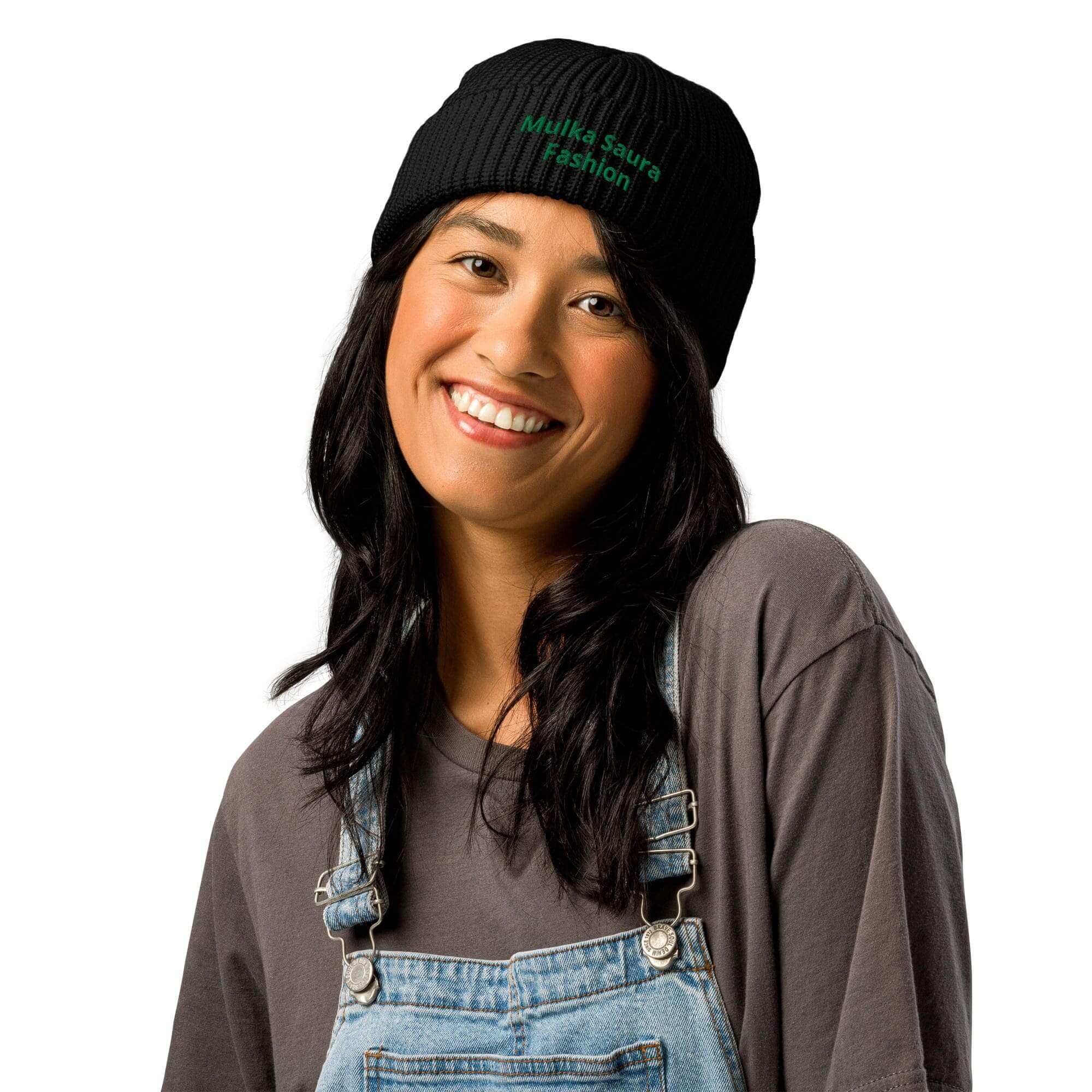 Smiling woman in overalls and beanie.