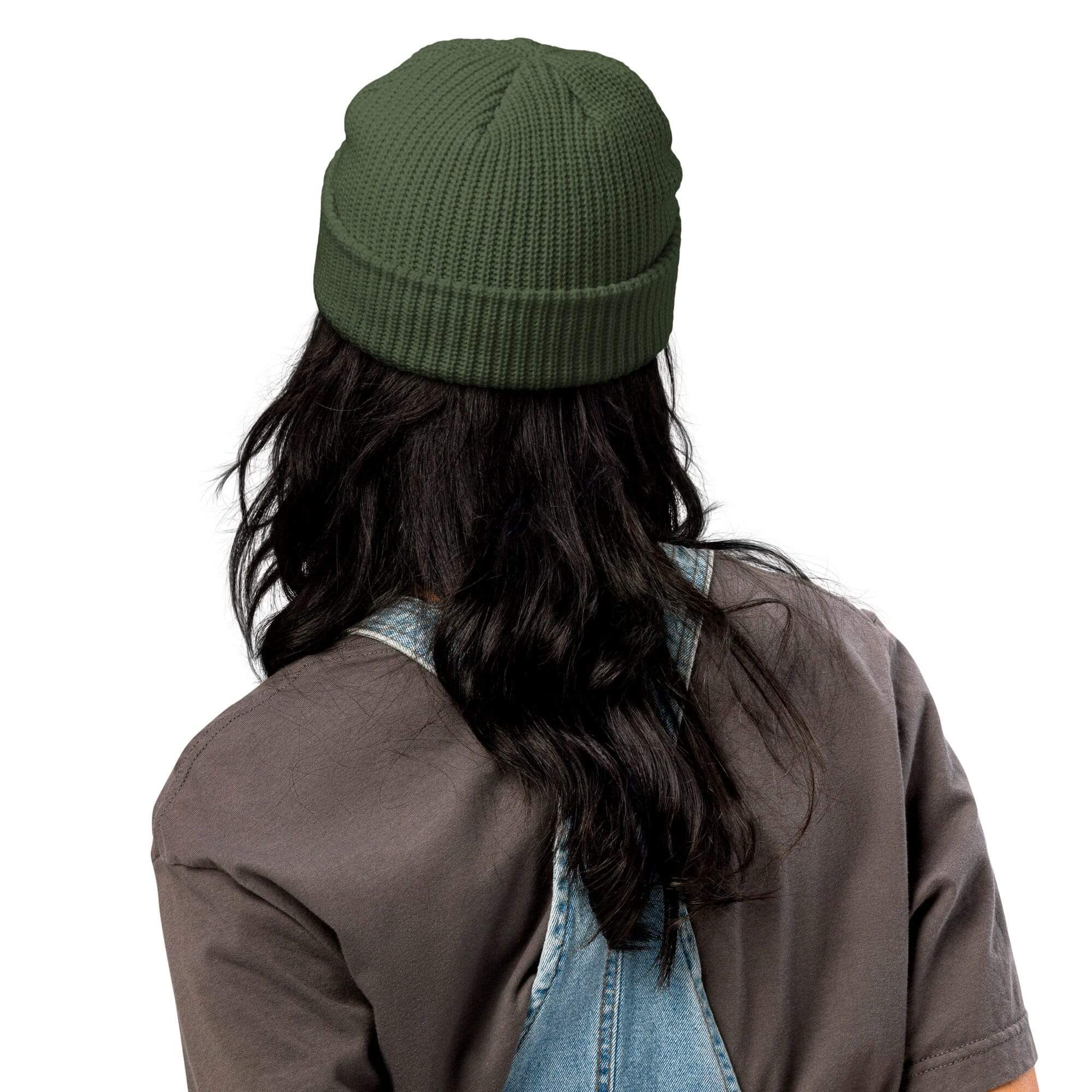 Person wearing green beanie, denim overalls.