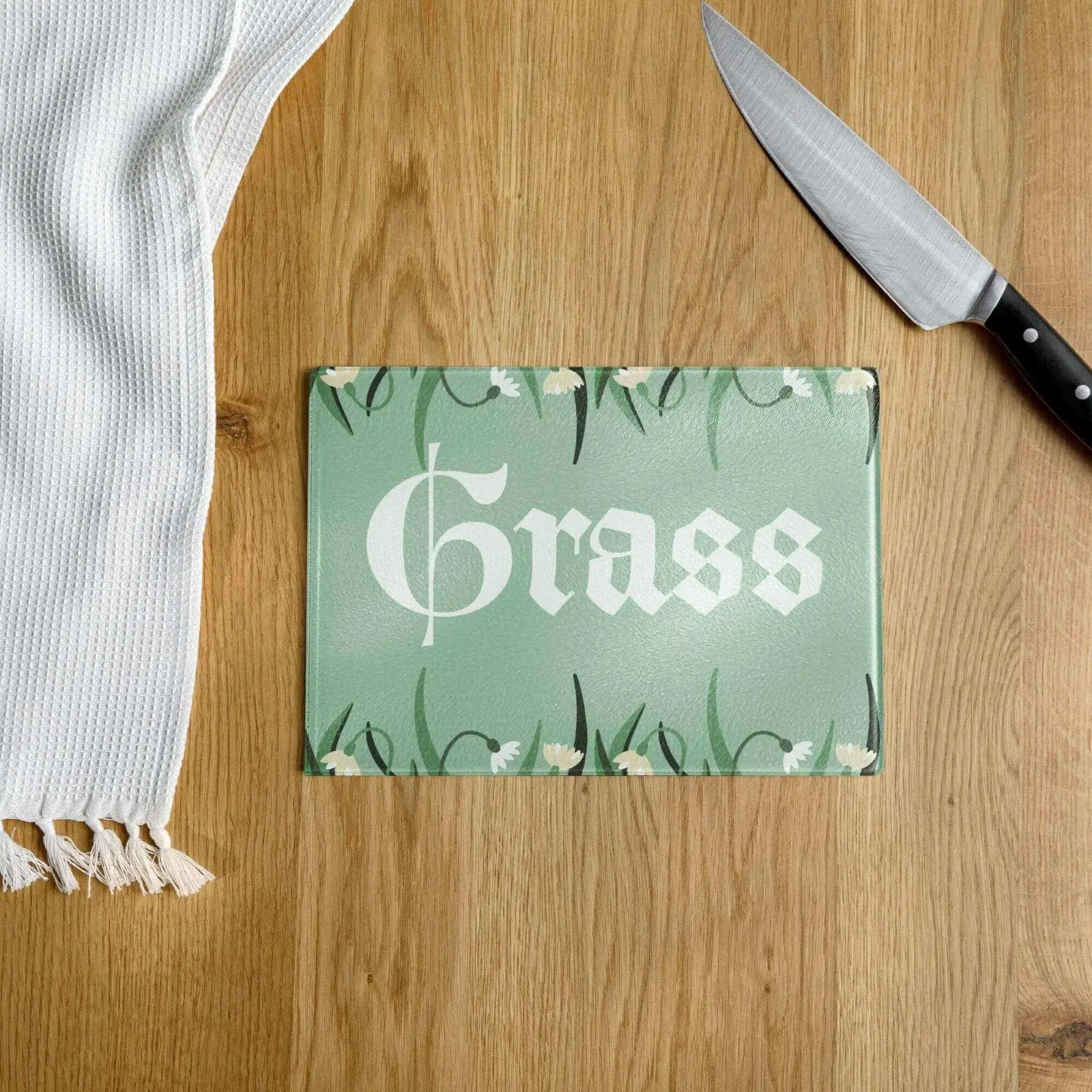Cutting board with "Grass" design on table.
