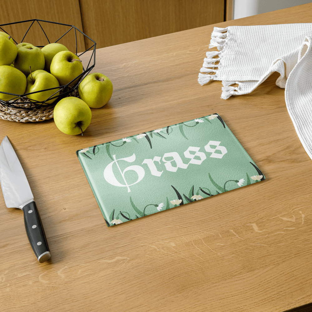 Cutting board with "Grass" on wooden table.