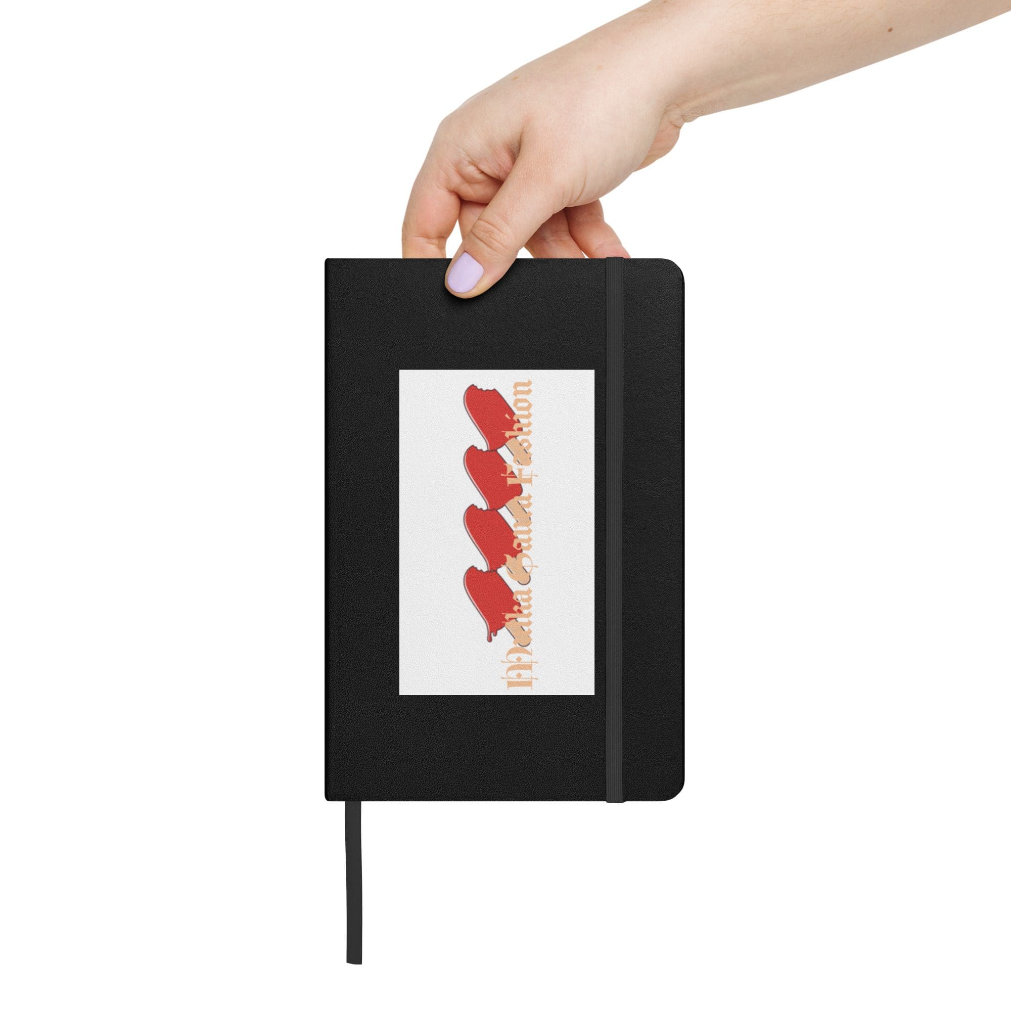 Hand holding black notebook with red design.