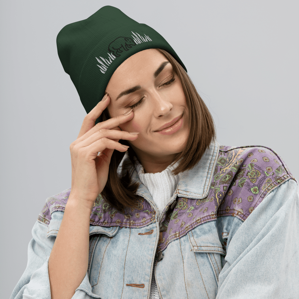 Woman smiling in green beanie and jacket.