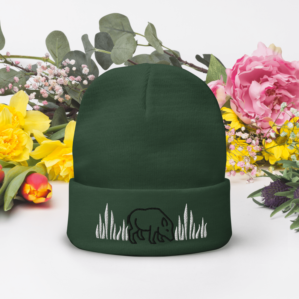 Green beanie with bear and grass design.
