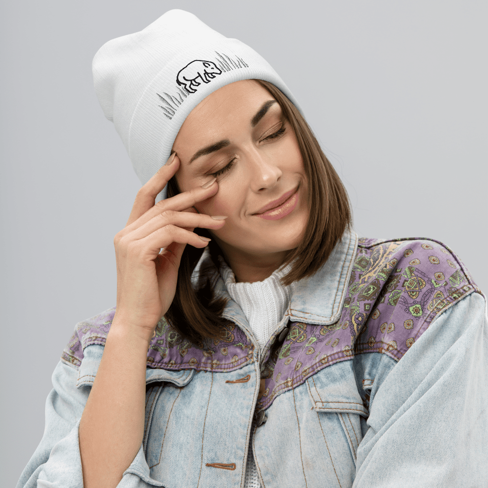 Woman in beanie with closed eyes smiling.