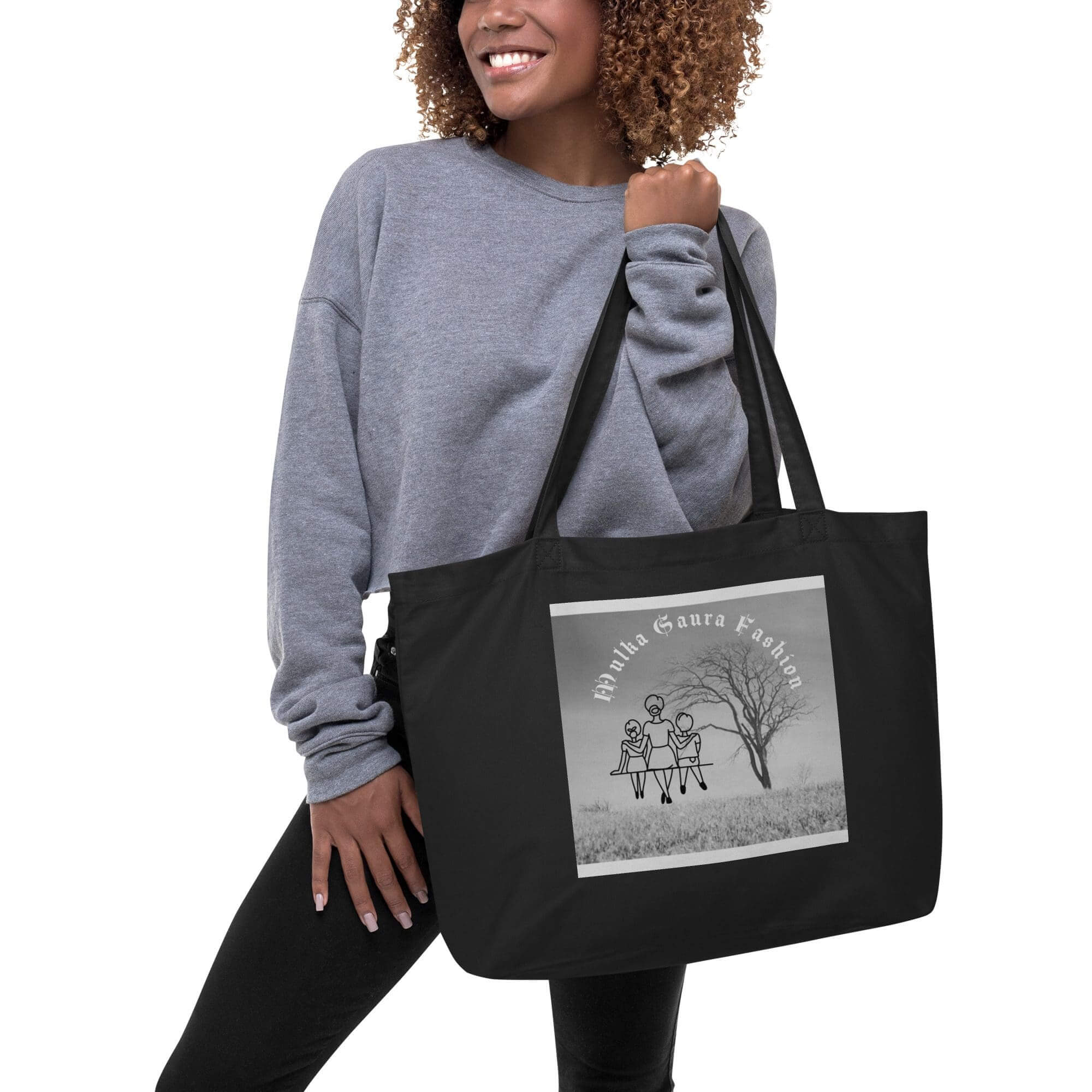 Woman holding black tote bag, smiling.