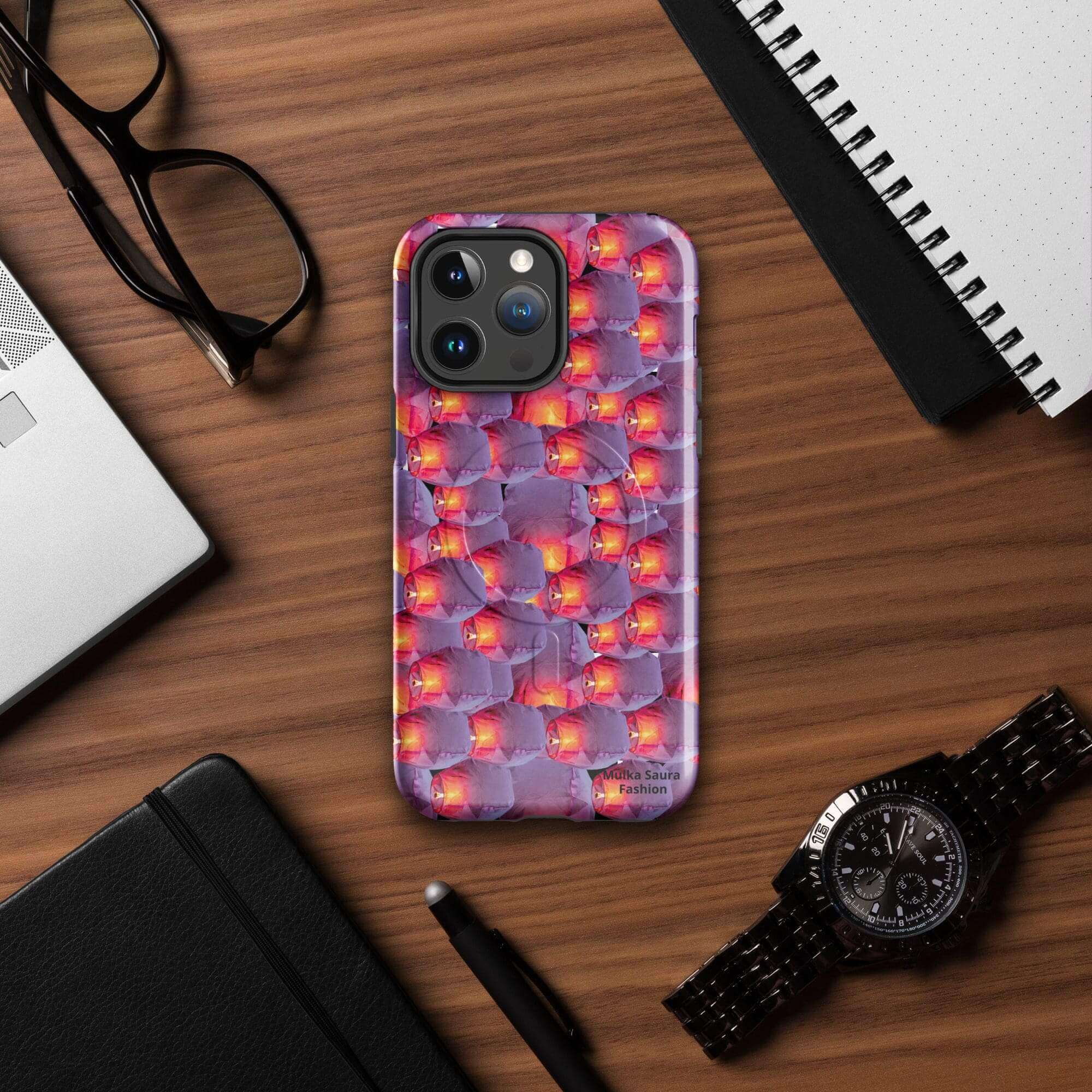 Phone with colorful case on wooden desk.