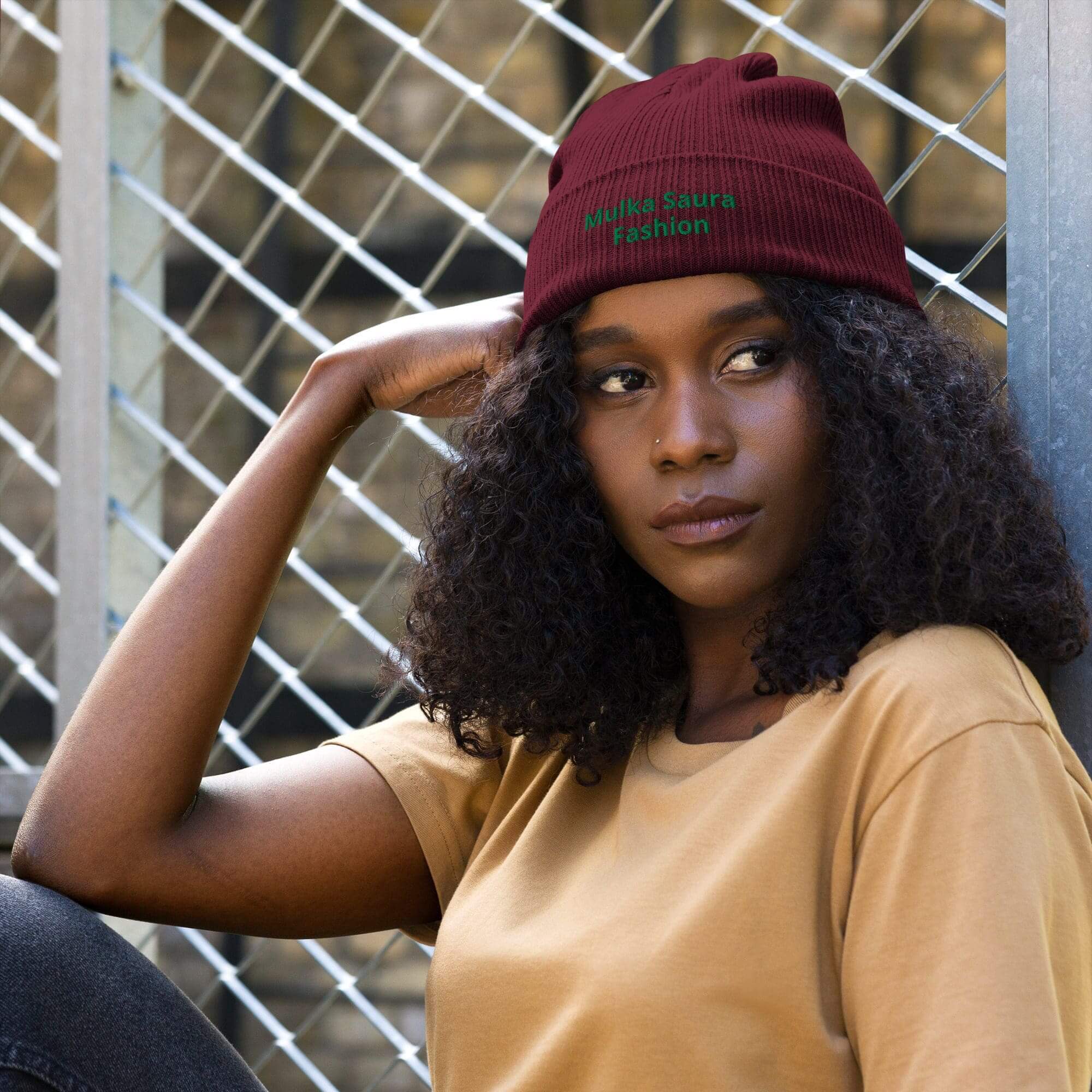 Woman wearing red beanie, sitting outdoors.