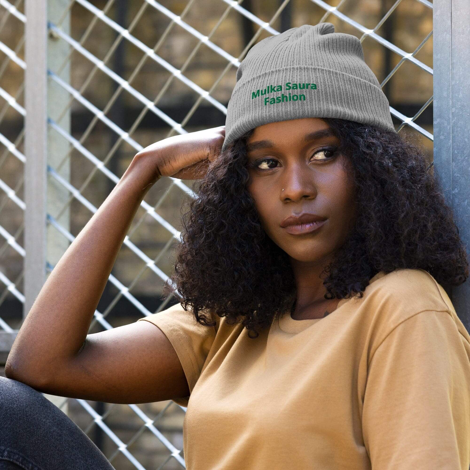 Woman wearing gray beanie, resting on arm.