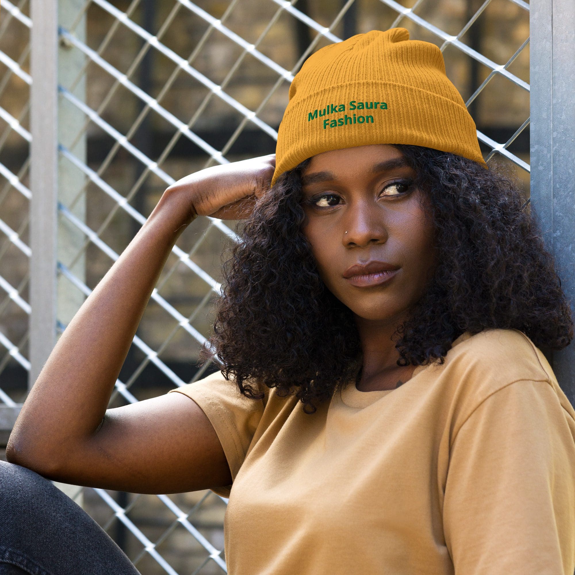 Woman in orange beanie and shirt outdoors.