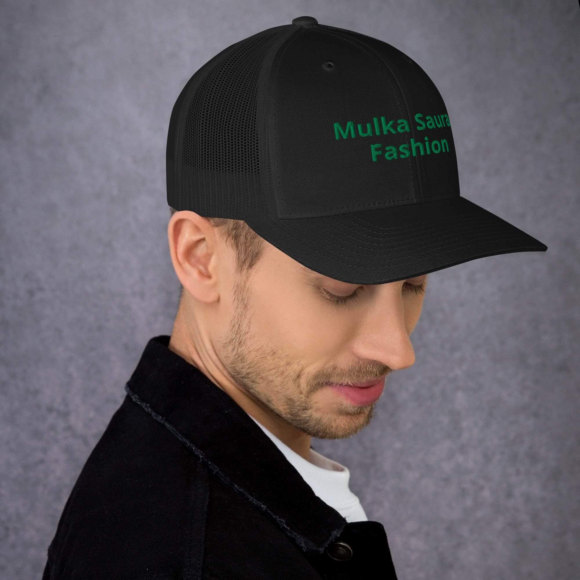 Man wearing black cap with green text.