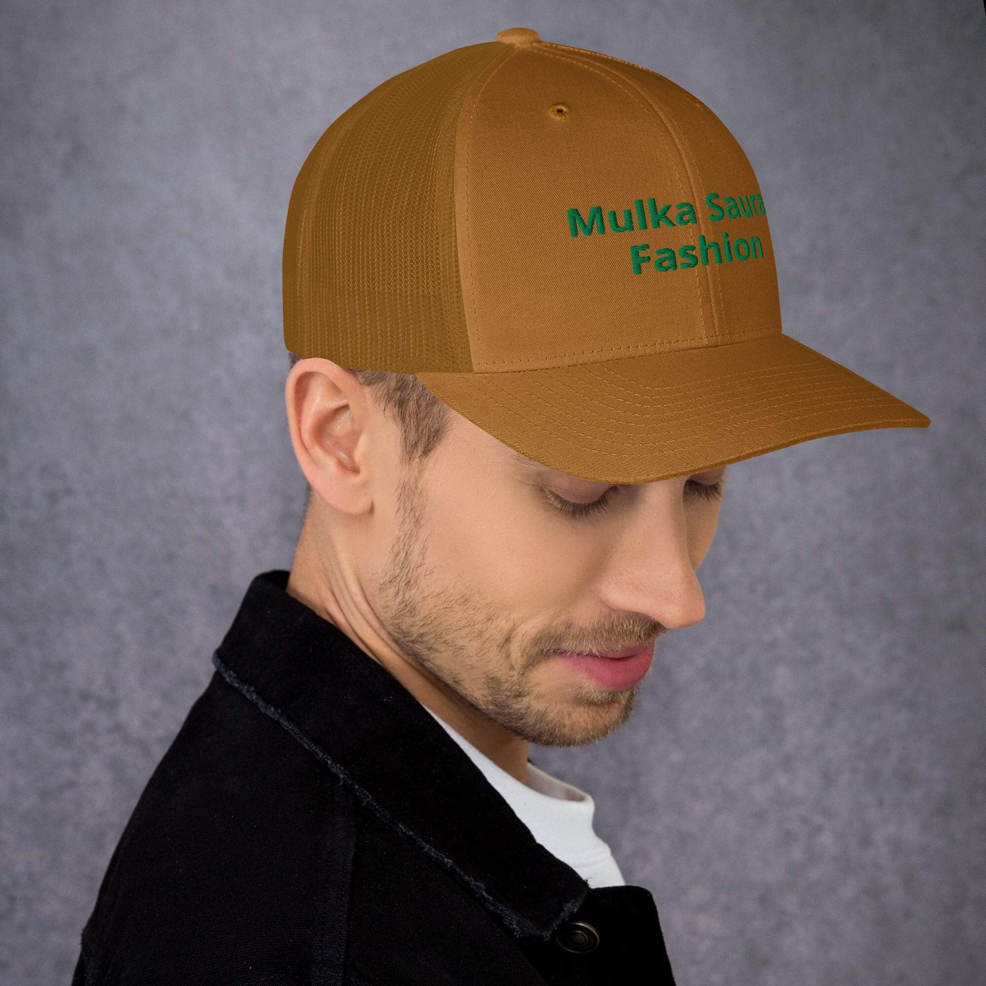 Man wearing brown embroidered cap with green text