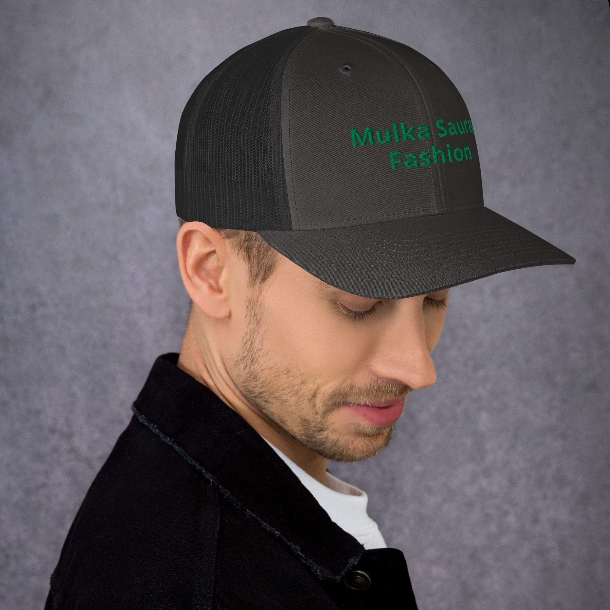 Man wearing a dark baseball cap, side view.