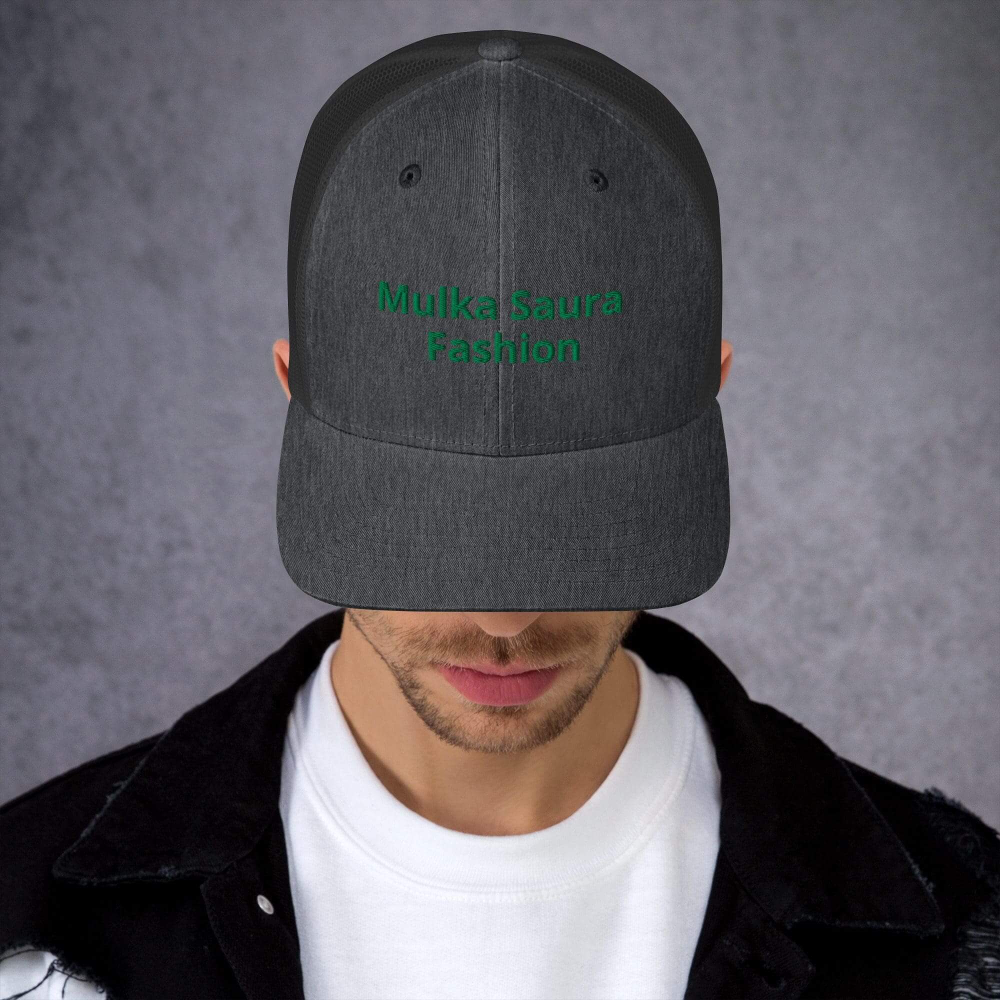 Man wearing dark cap with green embroidery.