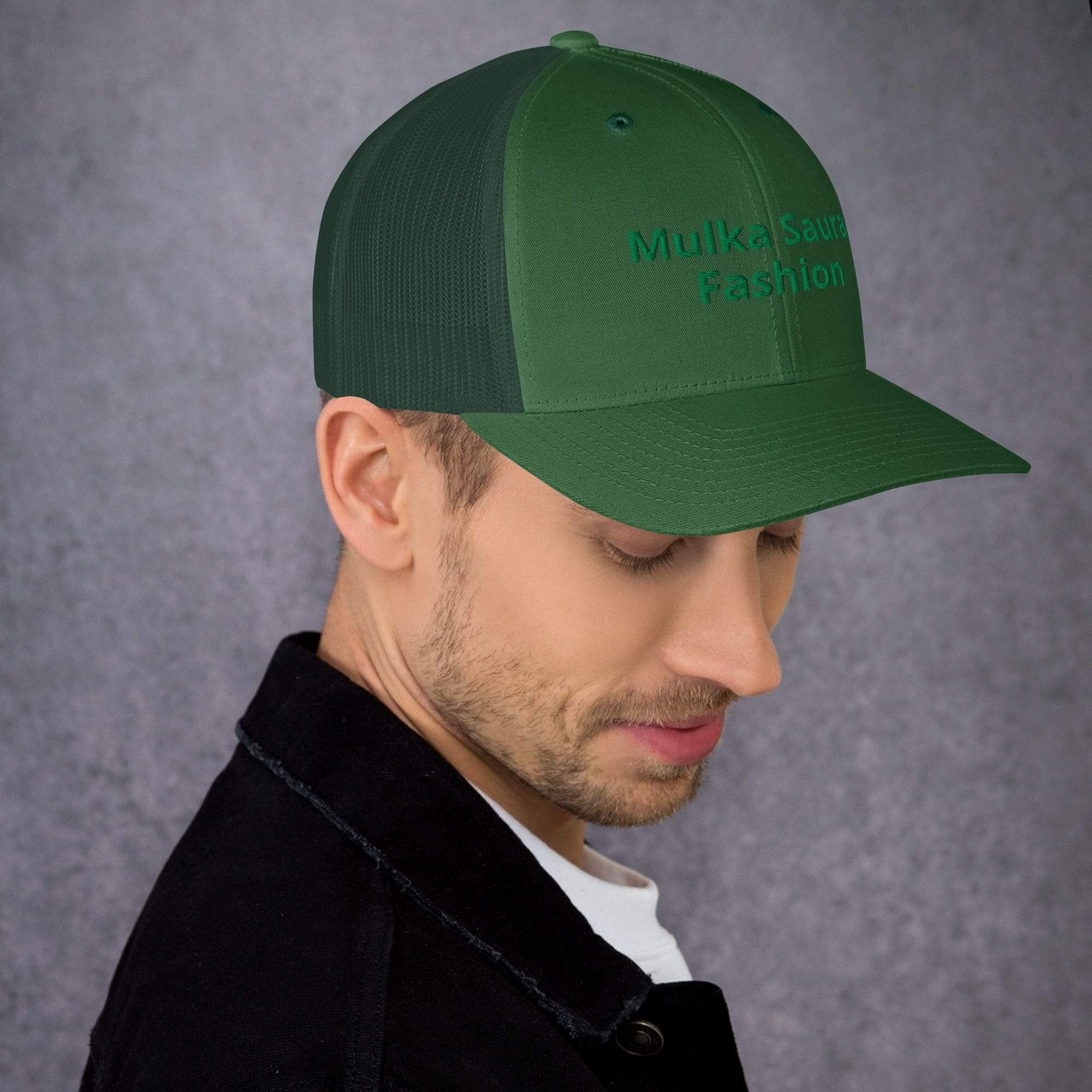 Man wearing green baseball cap looking down
