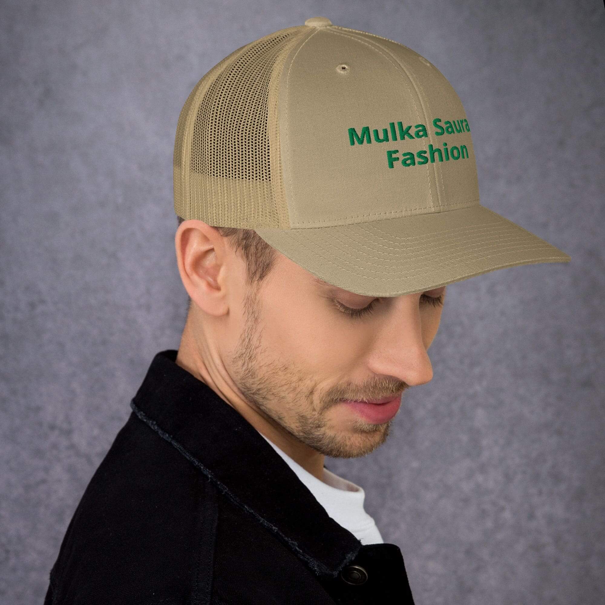 Man wearing beige cap with green text.