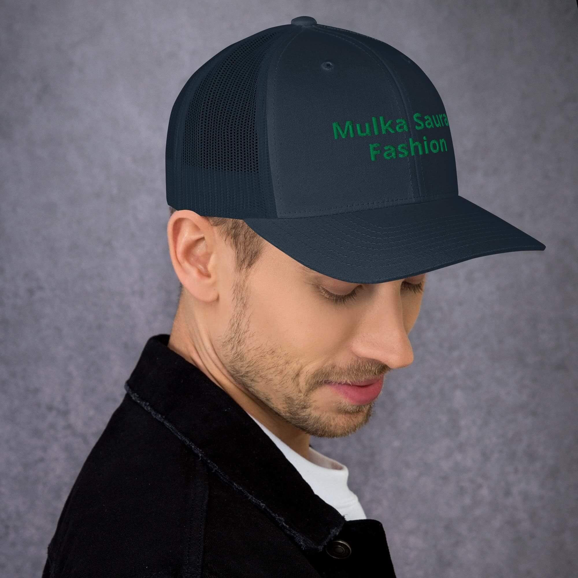 Man wearing black cap, gray background.