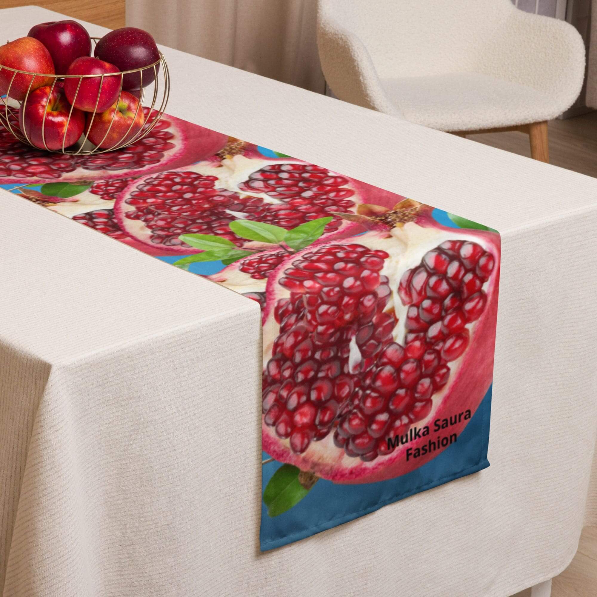 Table with pomegranate-themed runner and fruit.