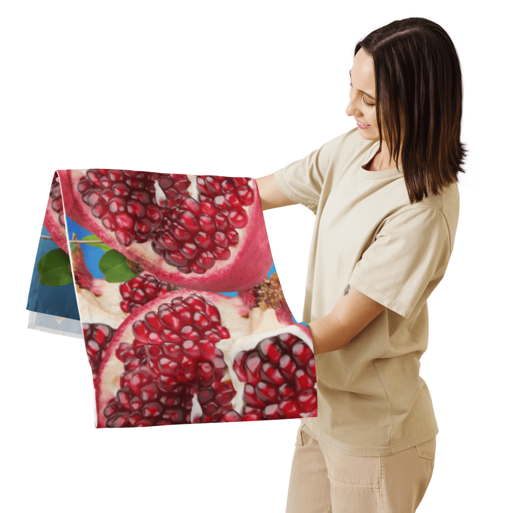 Person holding pomegranate-patterned towel, smiling.