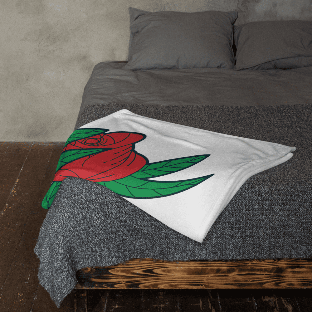 Bed with rose-patterned blanket and pillows.