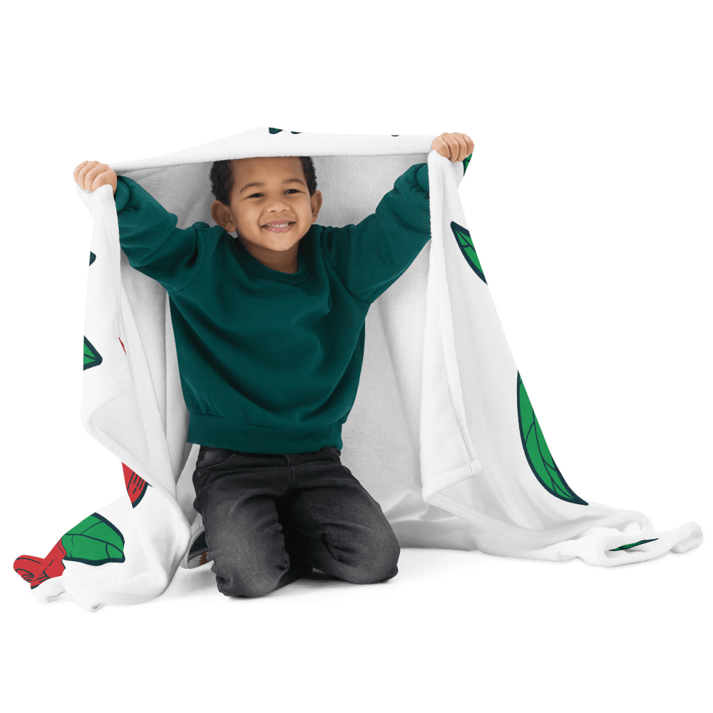 Child smiling under a colorful blanket.