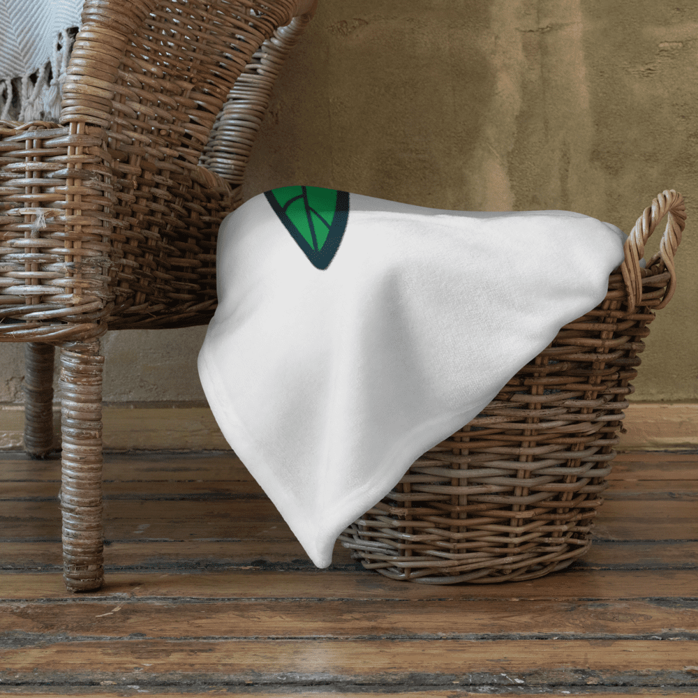 White blanket draped over wicker basket.
