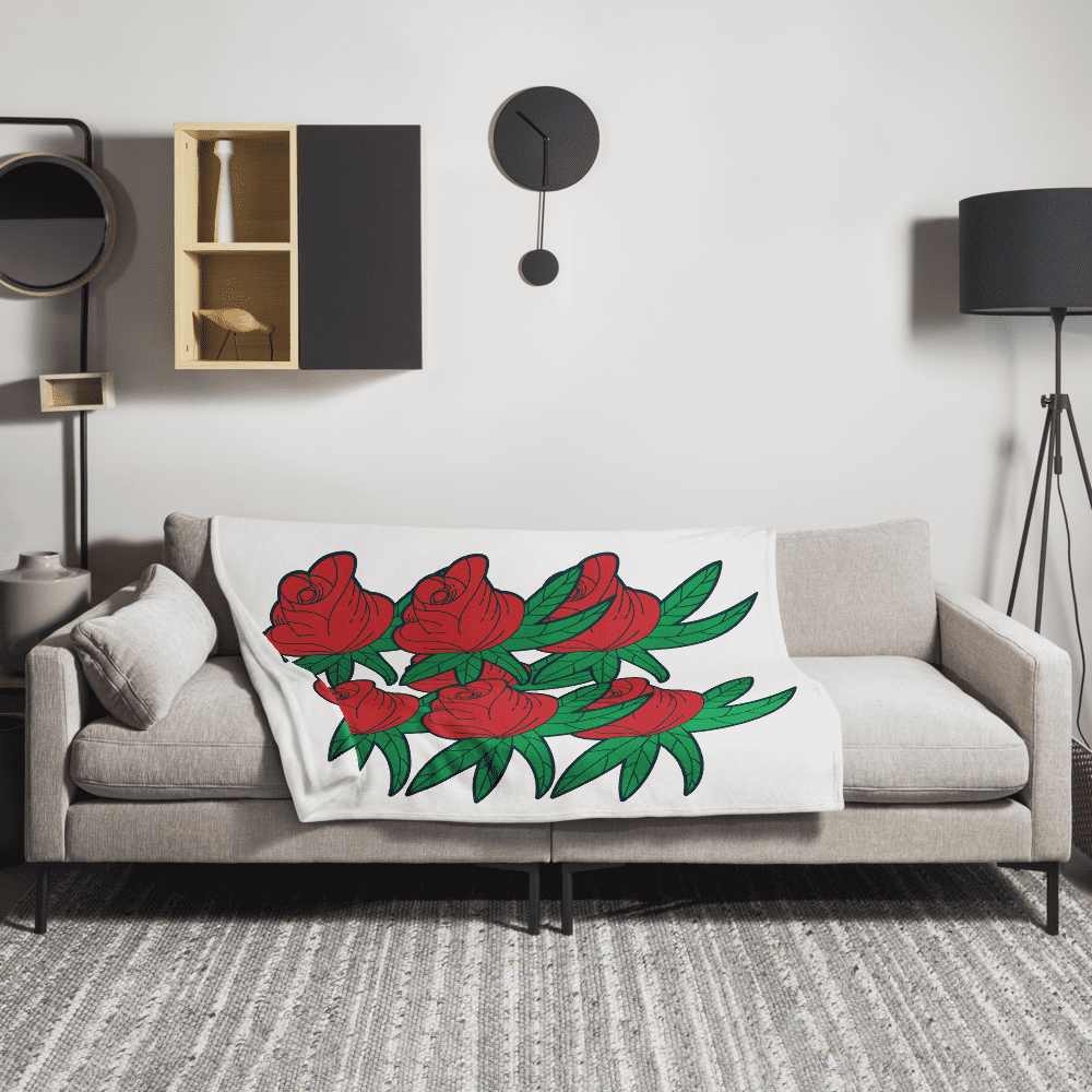 Sofa with red rose-patterned blanket.