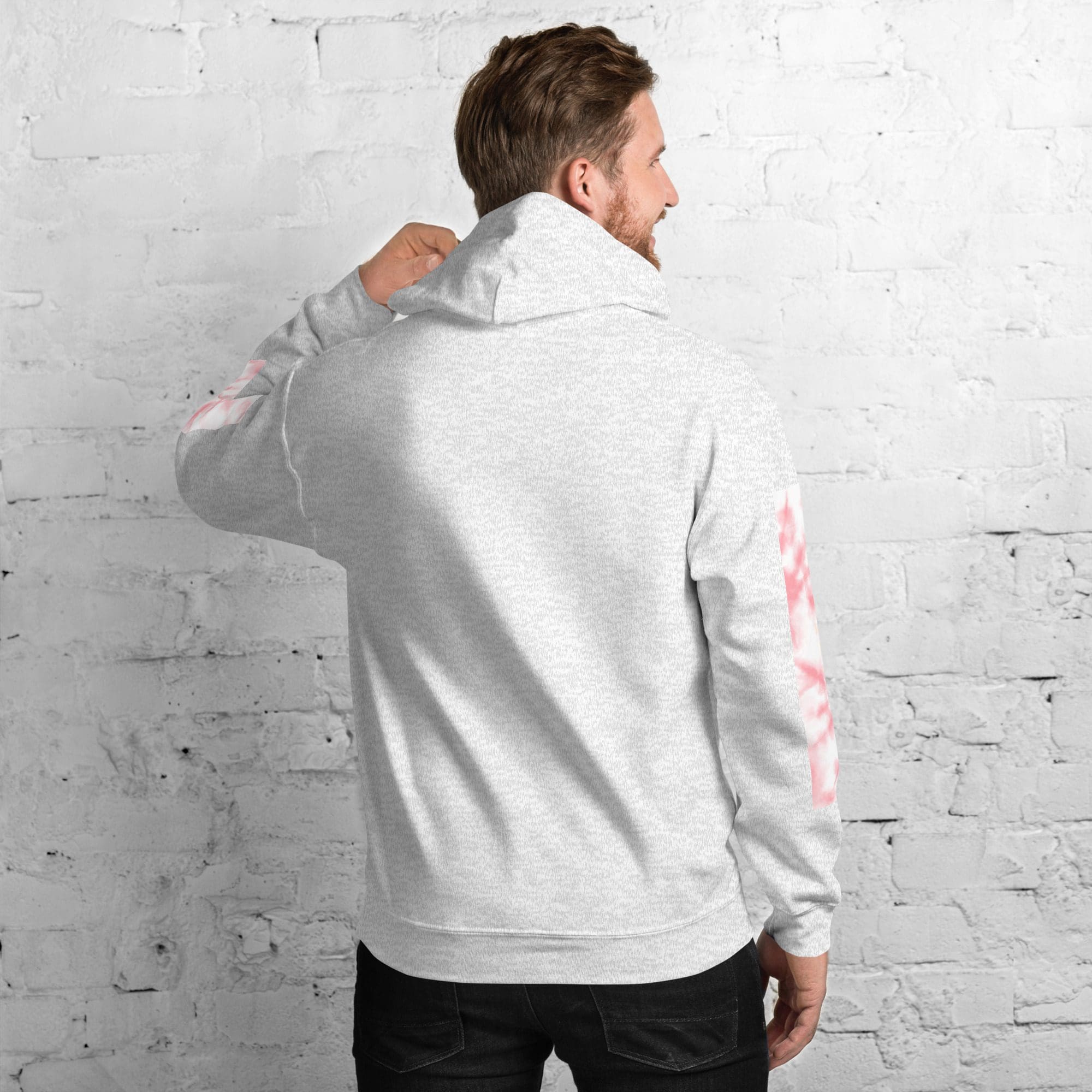 Man wearing a gray hoodie, brick wall background.