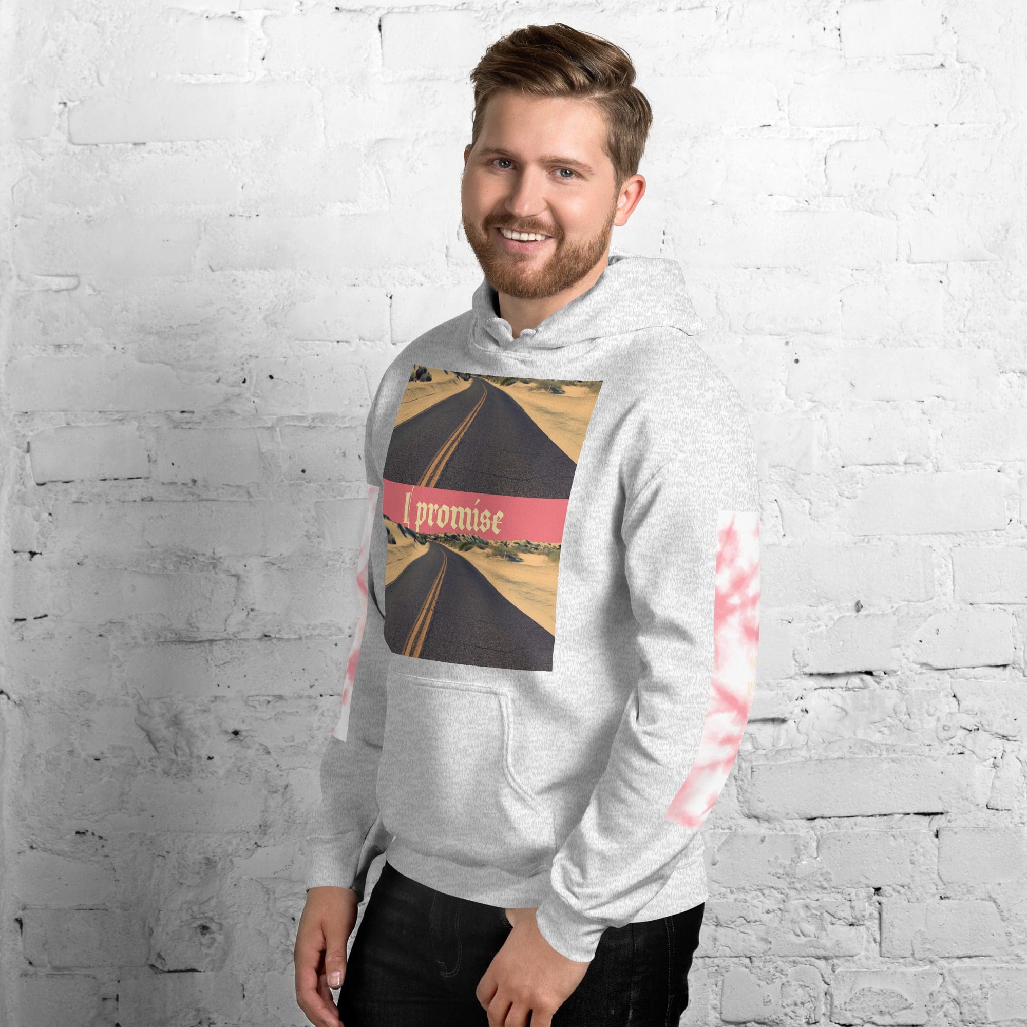 Man wearing gray hoodie, standing against brick wall.