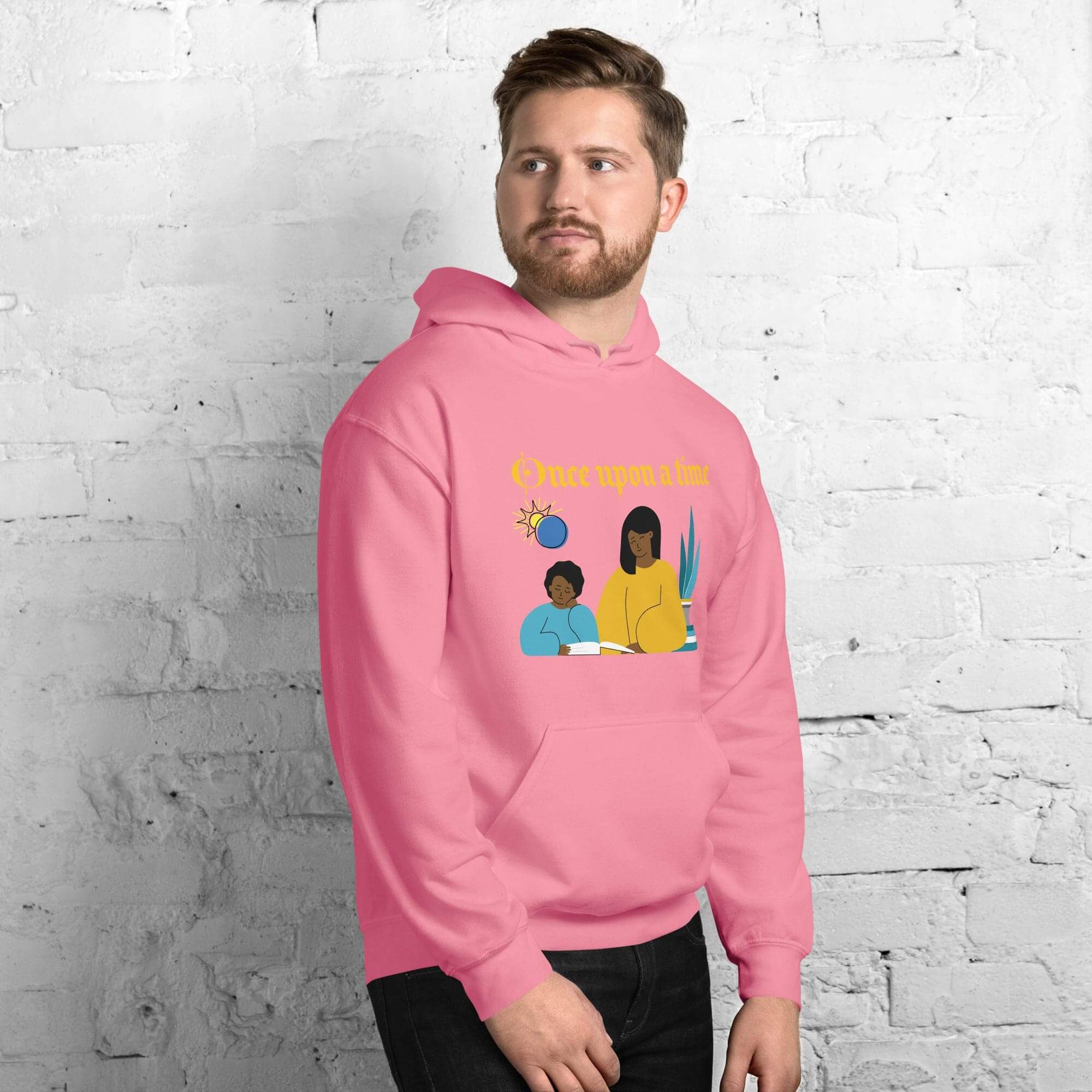 Man wearing pink hoodie against white brick wall.