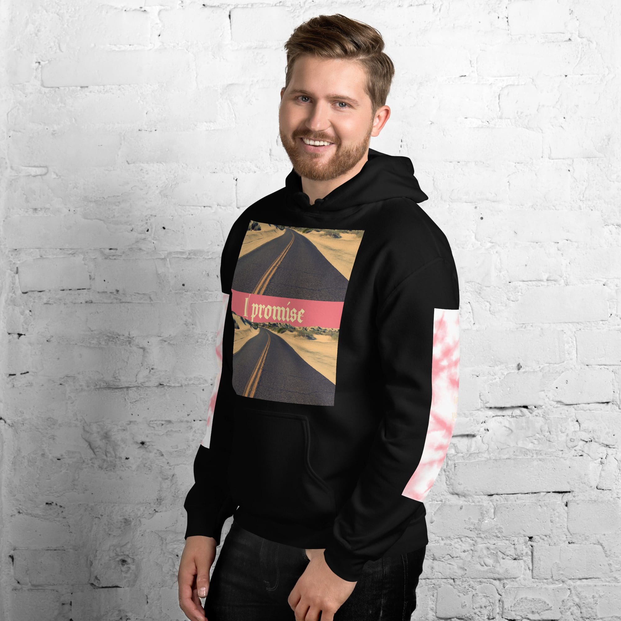 Man smiling in graphic hoodie, white background.
