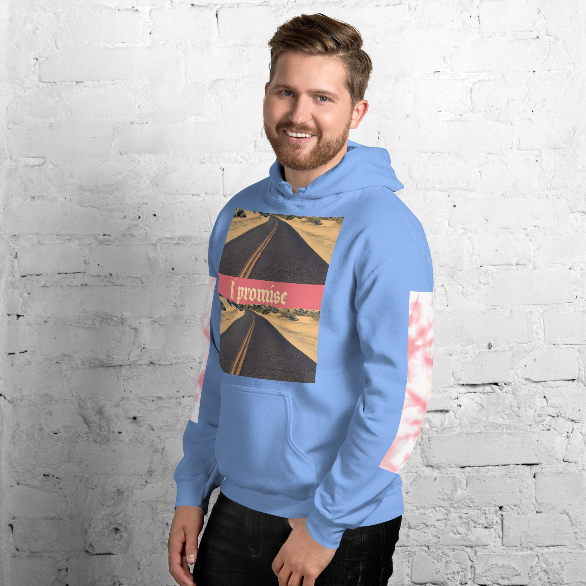 Man wearing blue hoodie, standing against brick wall.