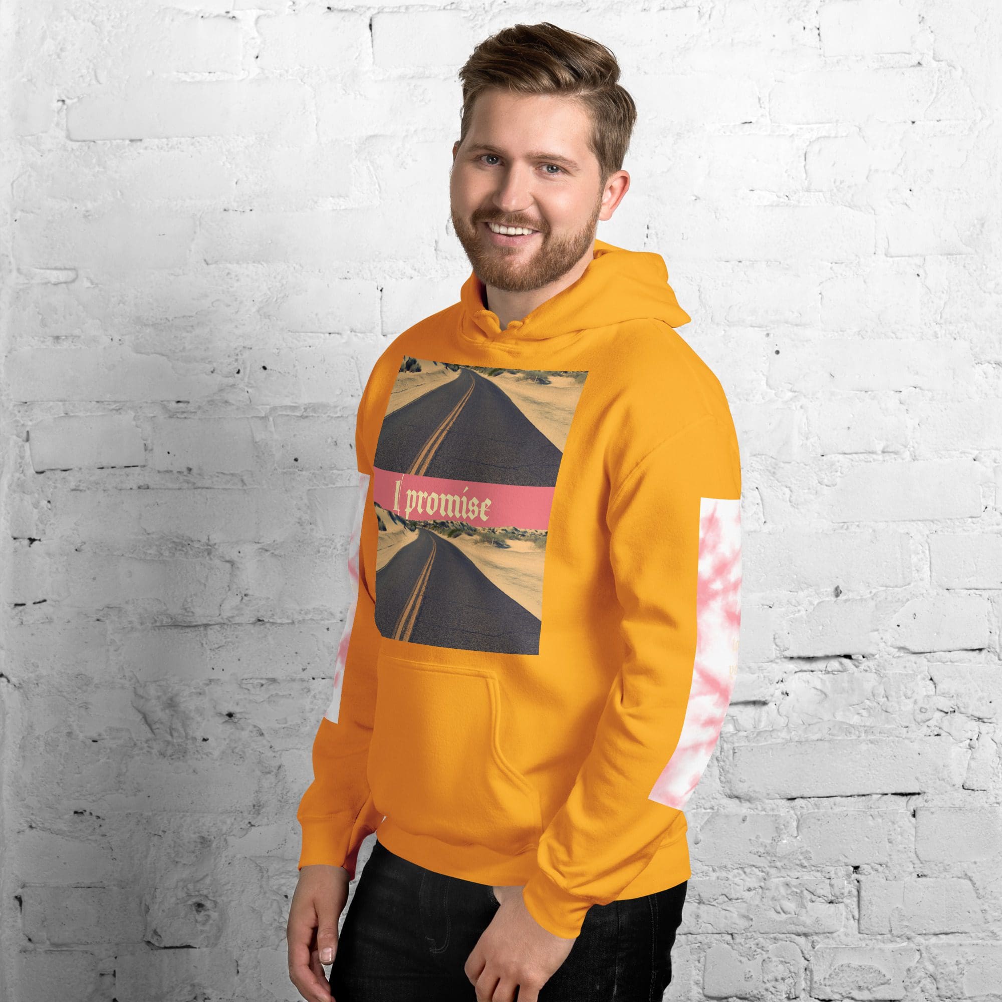 Man in orange hoodie, white brick background.