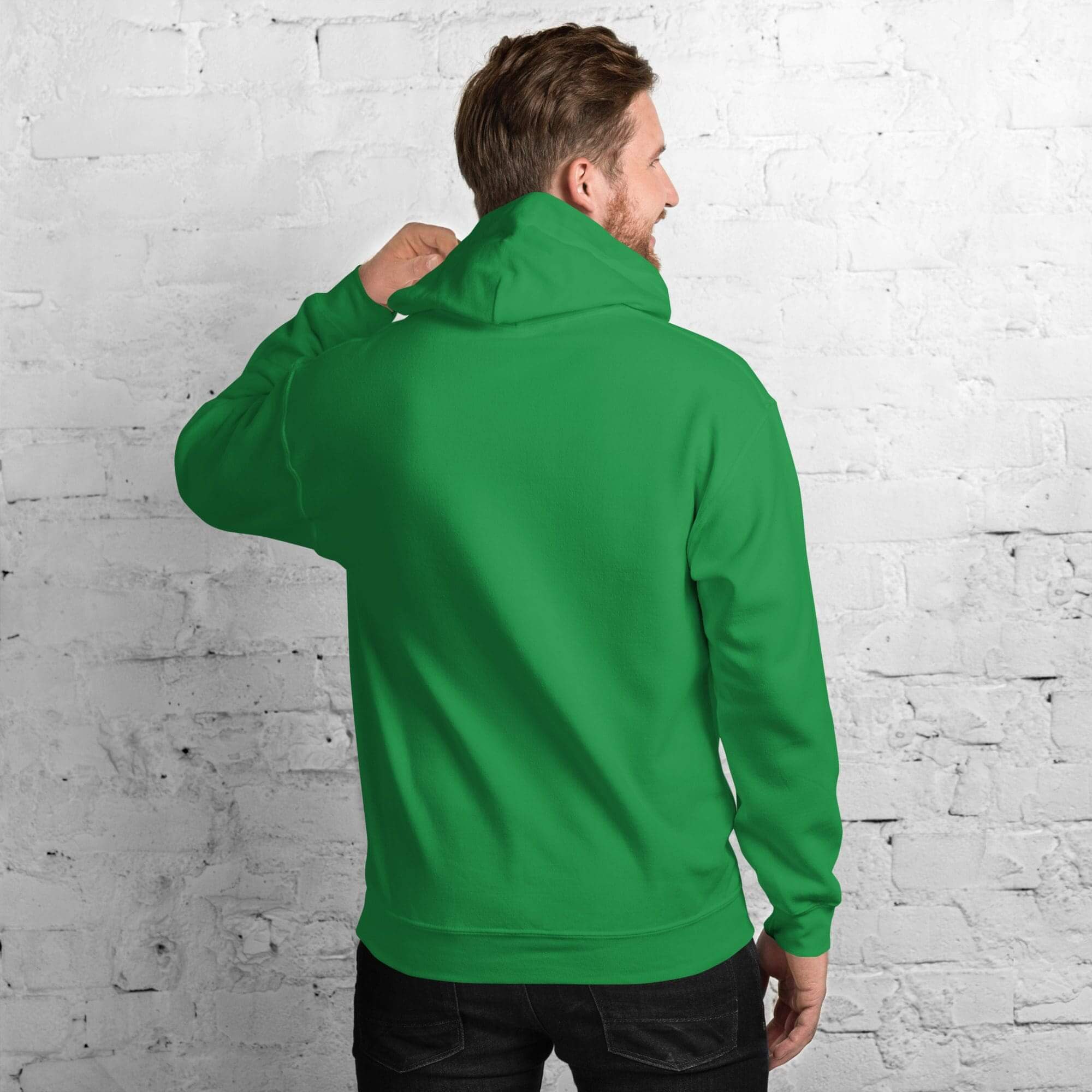 Man in green hoodie against brick wall