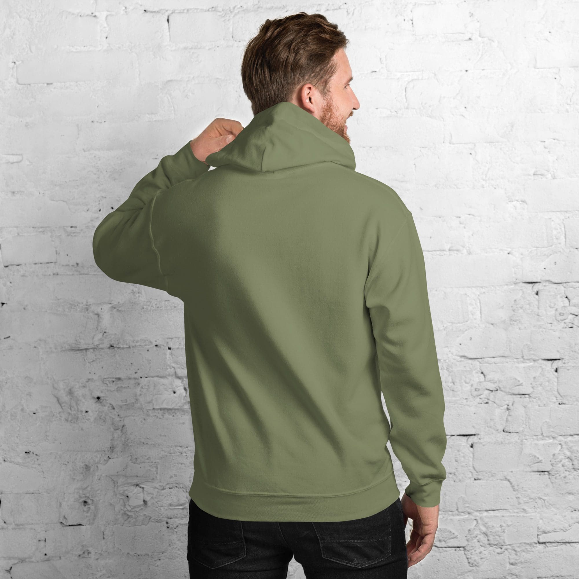 Man wearing olive green hoodie against brick wall