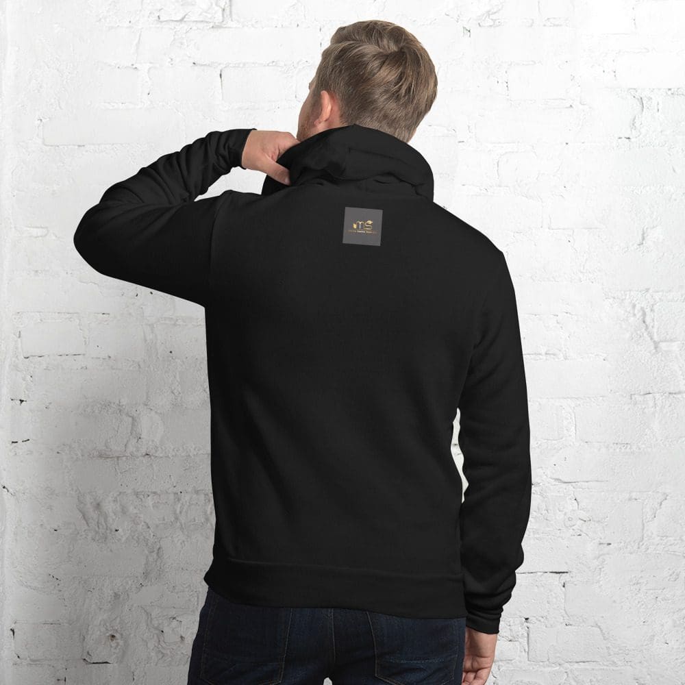 Man wearing black hoodie, facing brick wall.