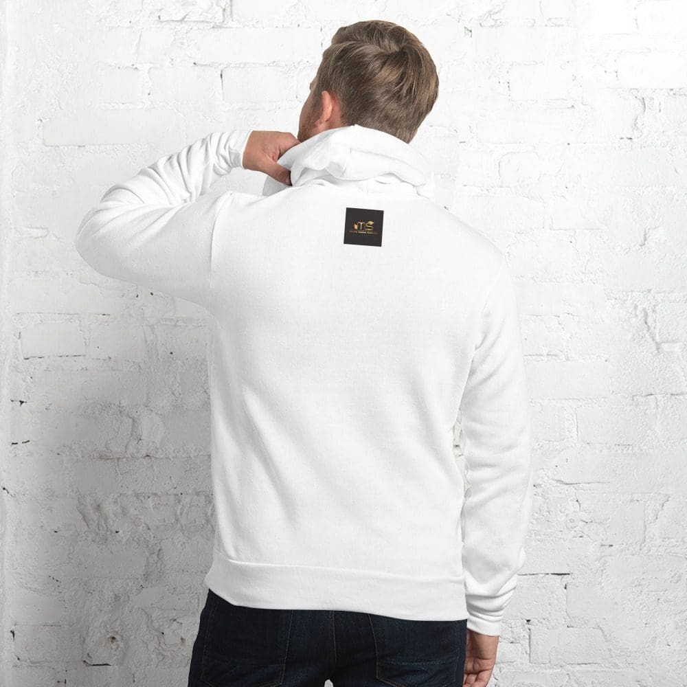 Man in white hoodie against white brick wall.