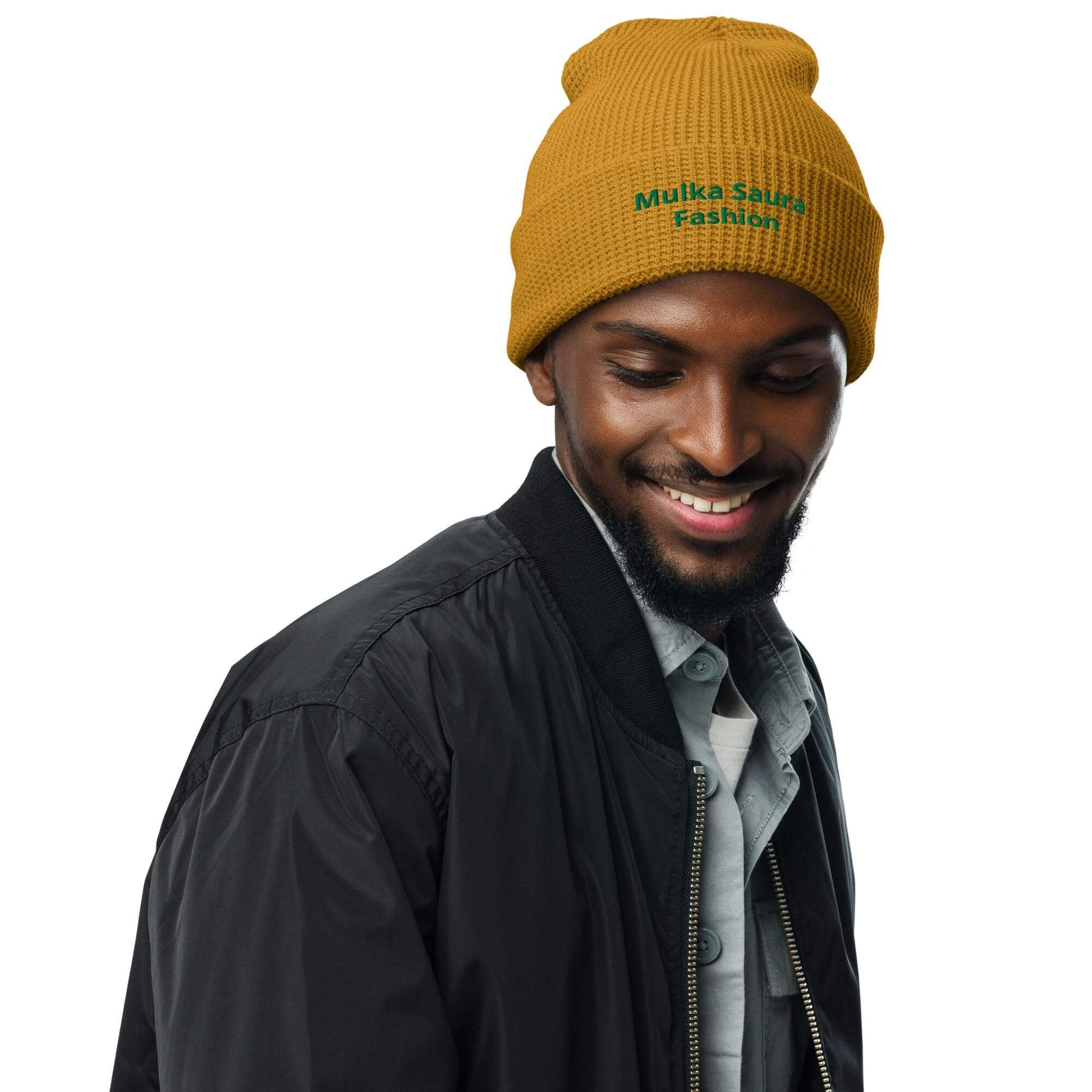 Man smiling in mustard beanie and jacket.