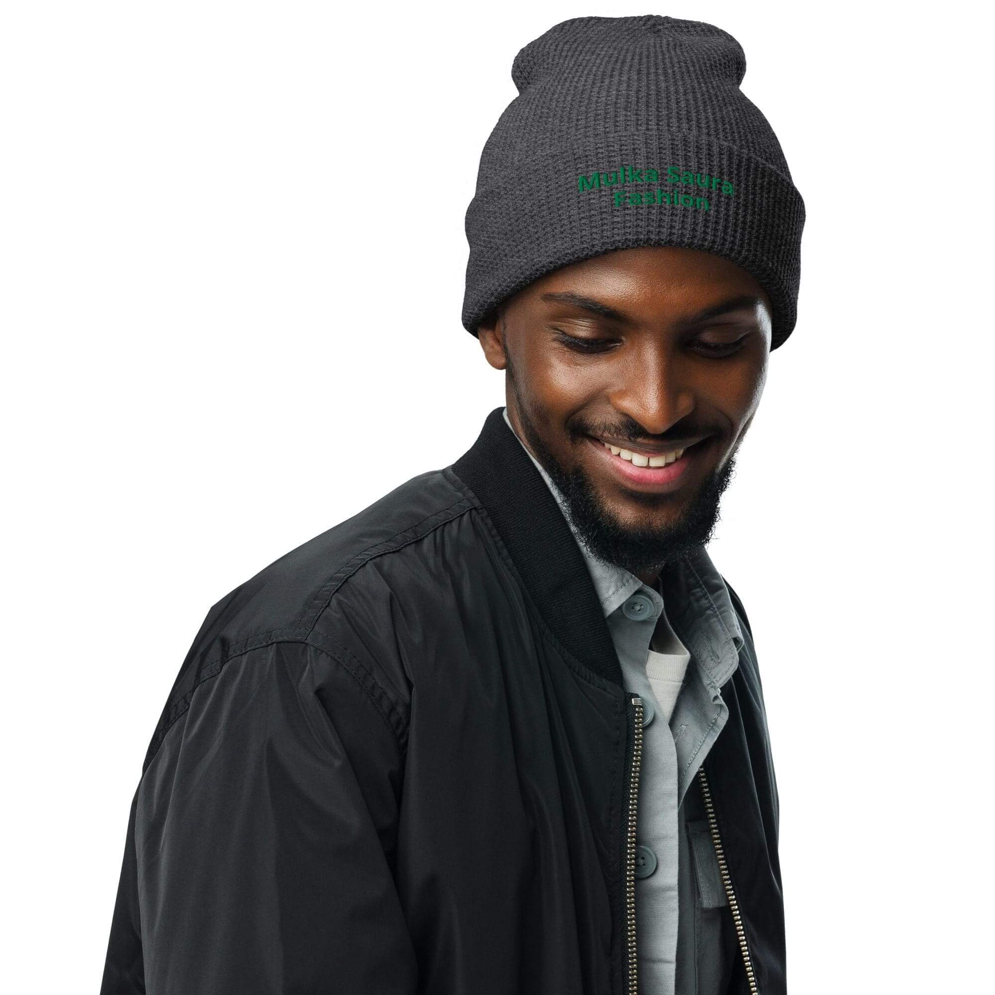 Man wearing beanie and black jacket smiling.