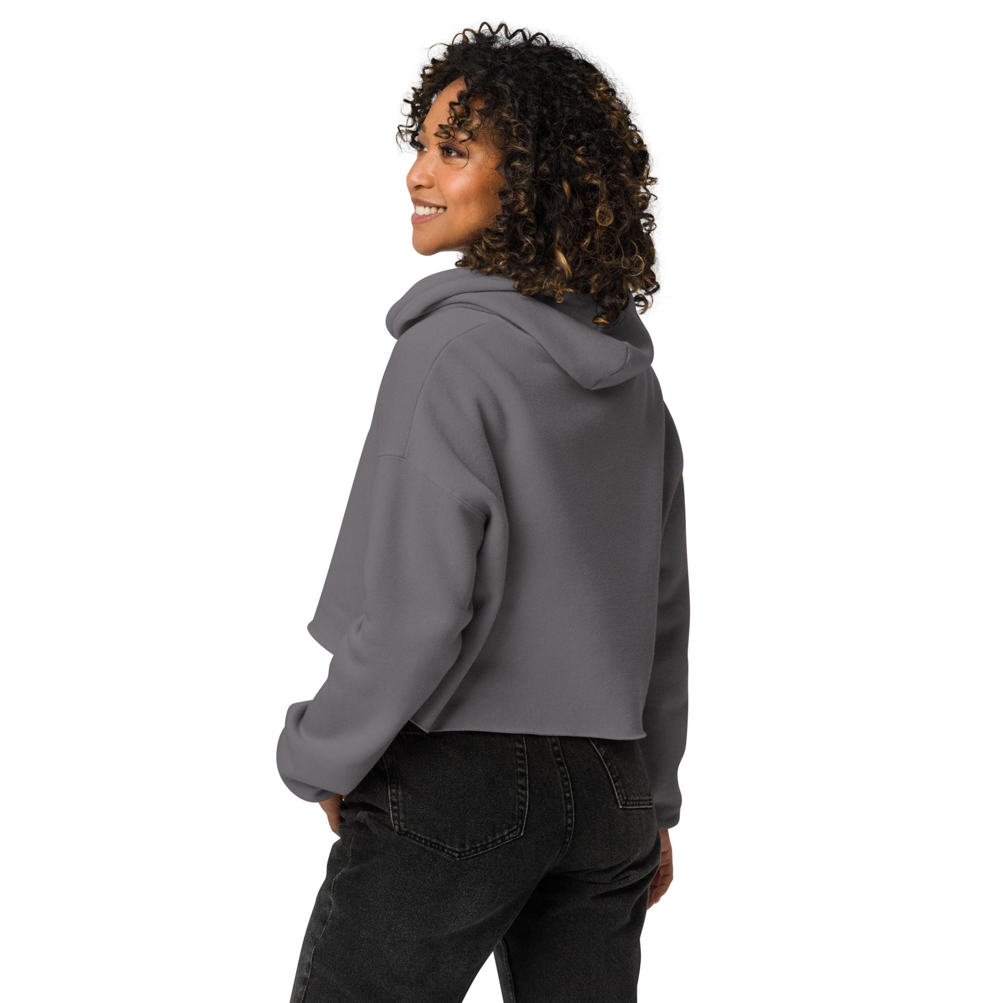 Woman wearing gray hoodie, smiling, looking sideways.
