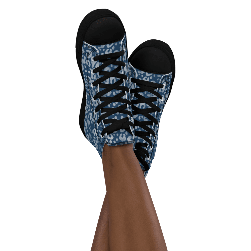Blue patterned sneakers on crossed legs.