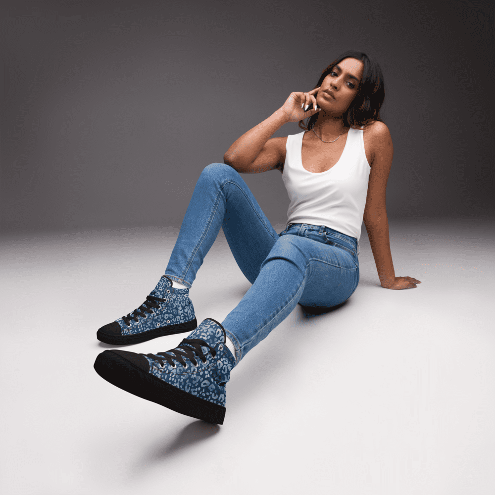 Woman sitting, wearing jeans and sneakers.