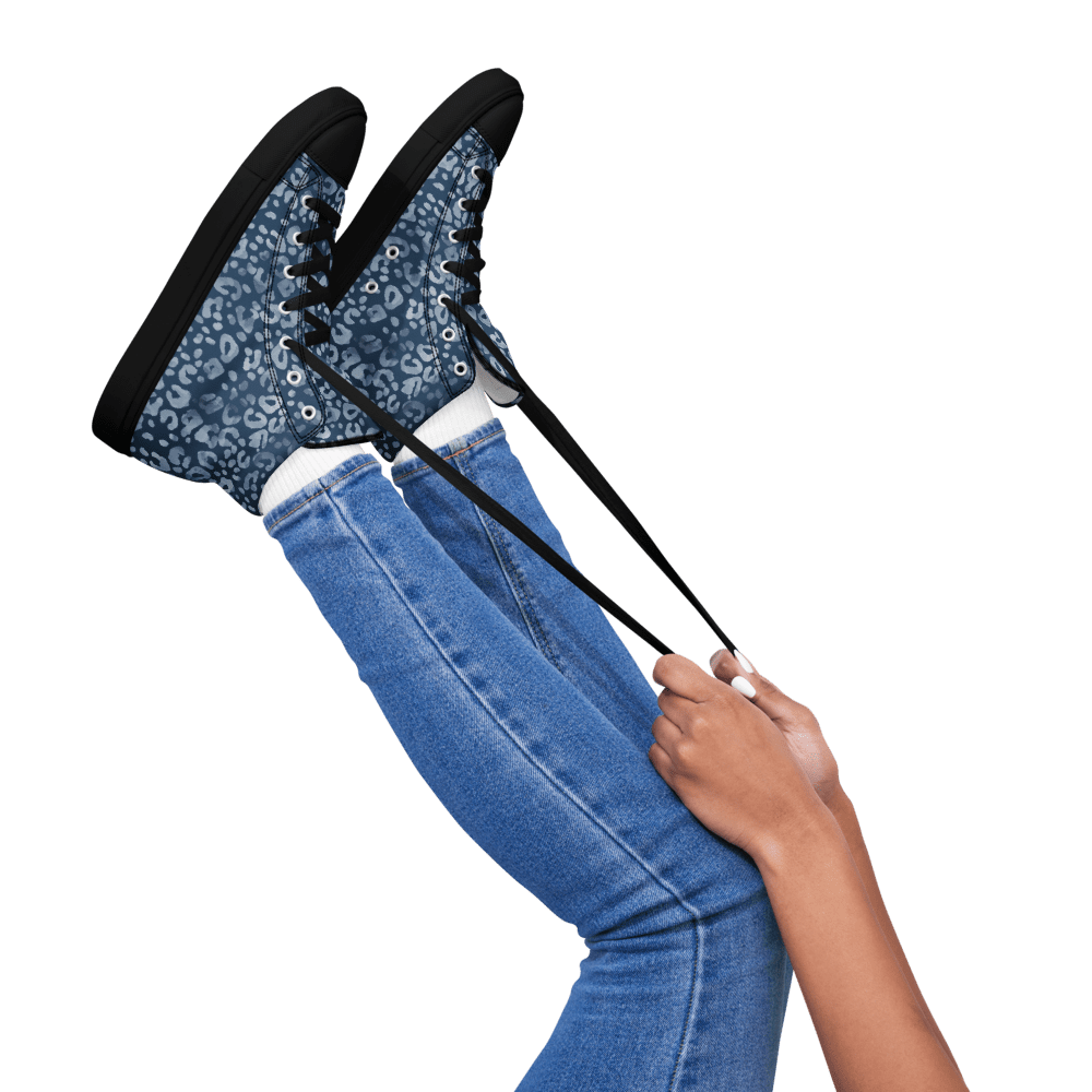 Person tying blue patterned sneakers laces.