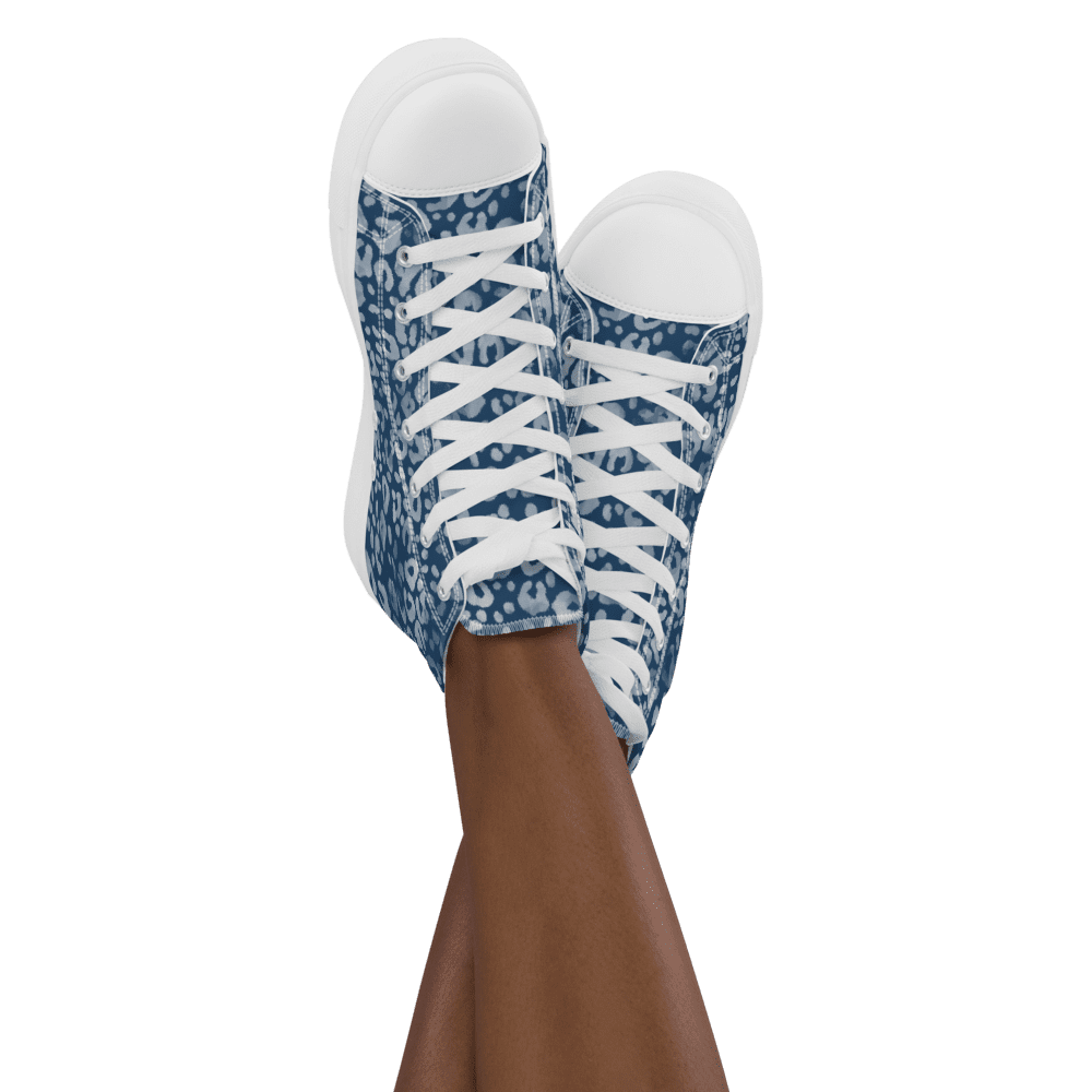 Blue patterned high-top sneakers on crossed legs